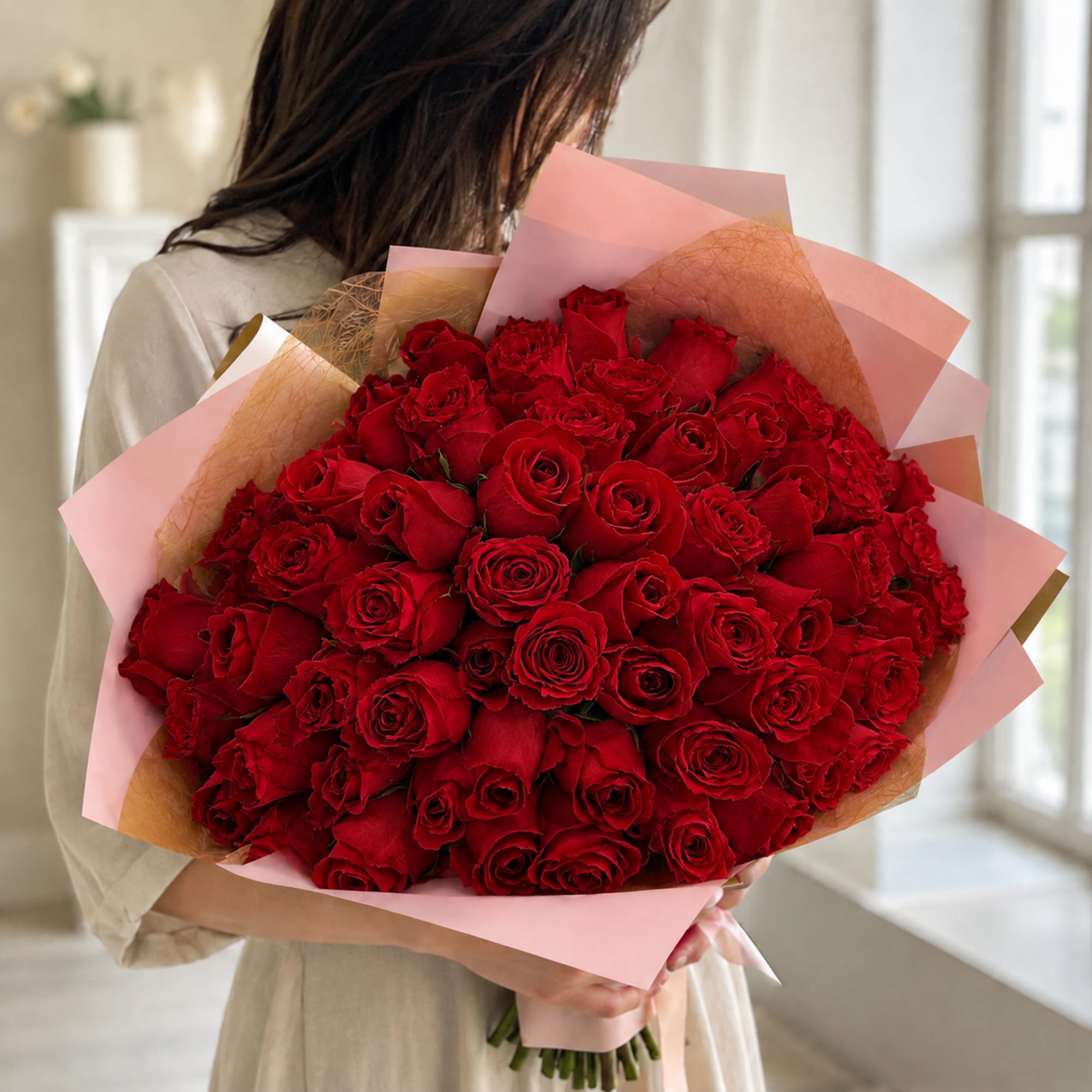 Large bouquet of red roses wrapped in pink paper