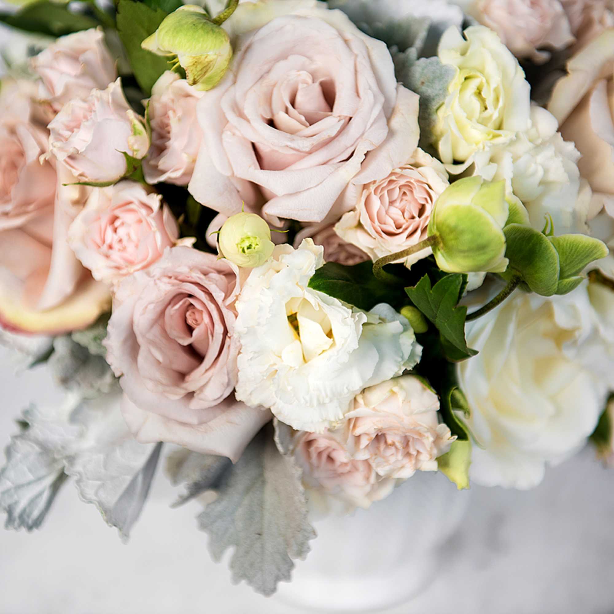 The Blush Bliss arrangement pairs soft blush roses, white hydrangeas, lisianthus, and