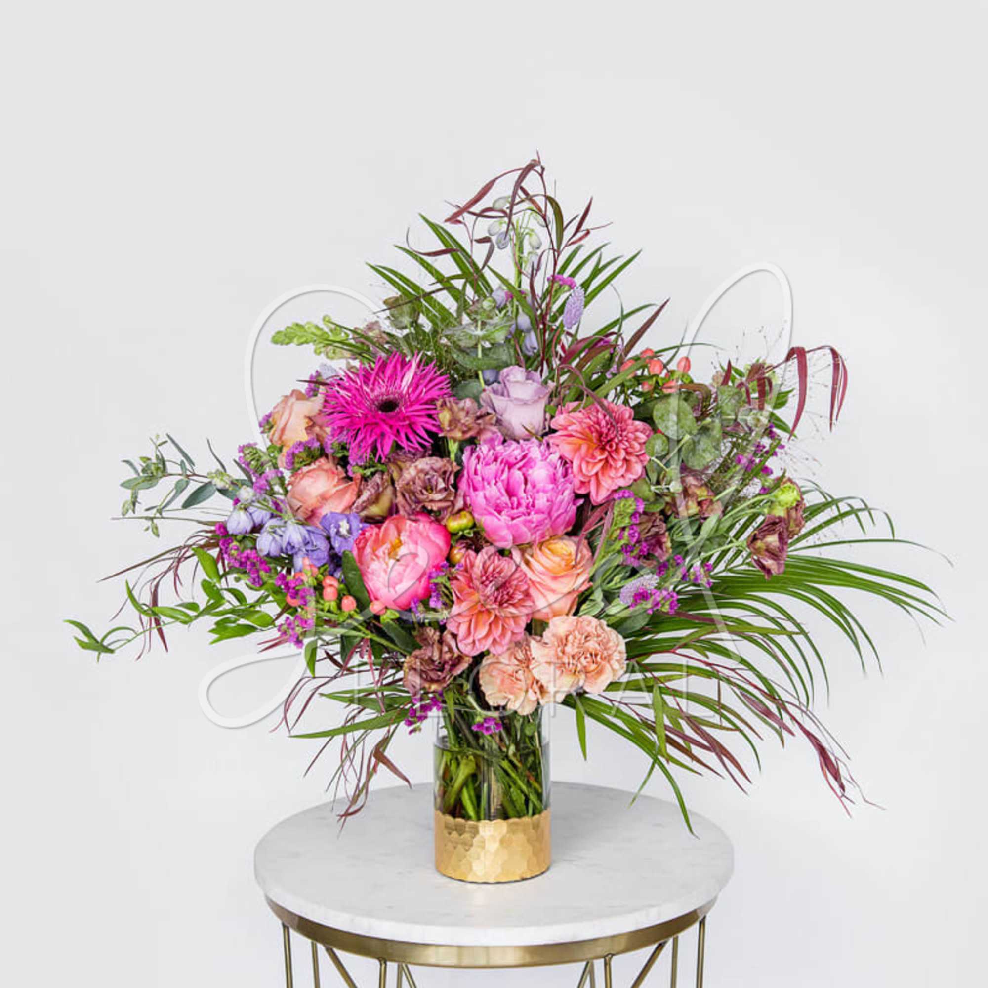 Large mixed bouquet in a glass vase with pink and peach flowers