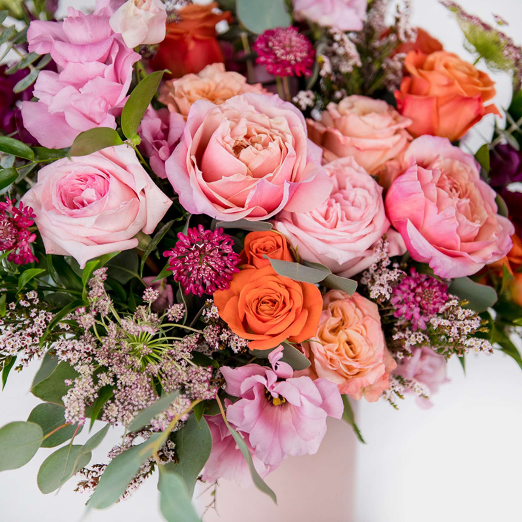 Bouquet of pink and orange roses with small filler flowers