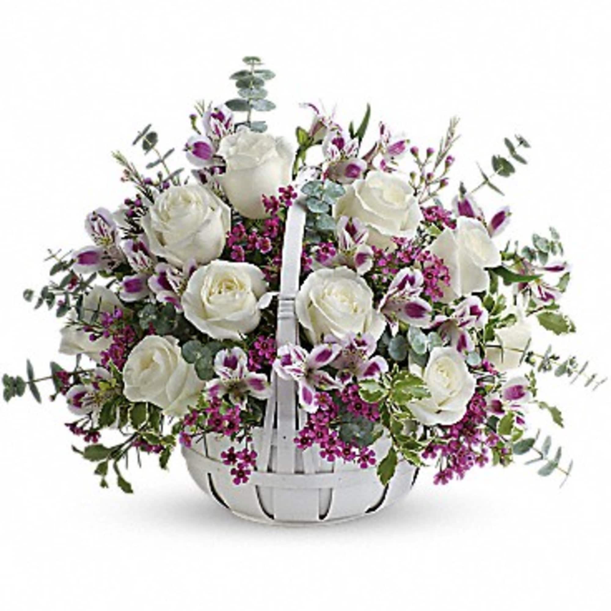 White roses and purple orchids in a white basket