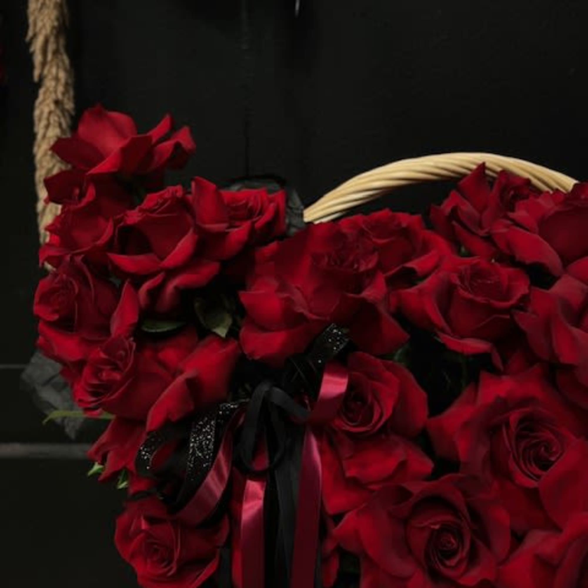A huge brown basket with beautiful large, inverted roses with long ribbons
