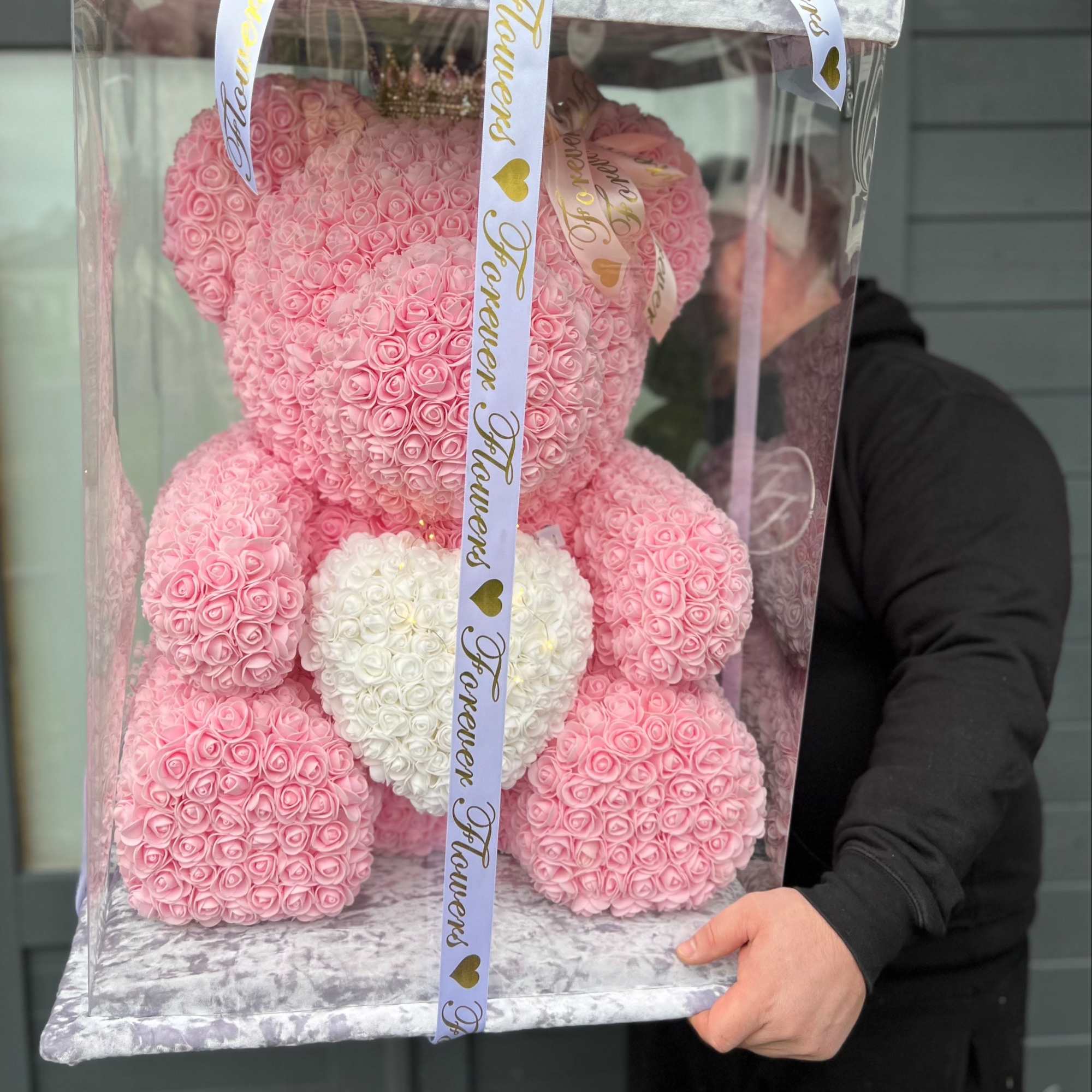 Pink rose teddy bear in a clear gift box with a white heart