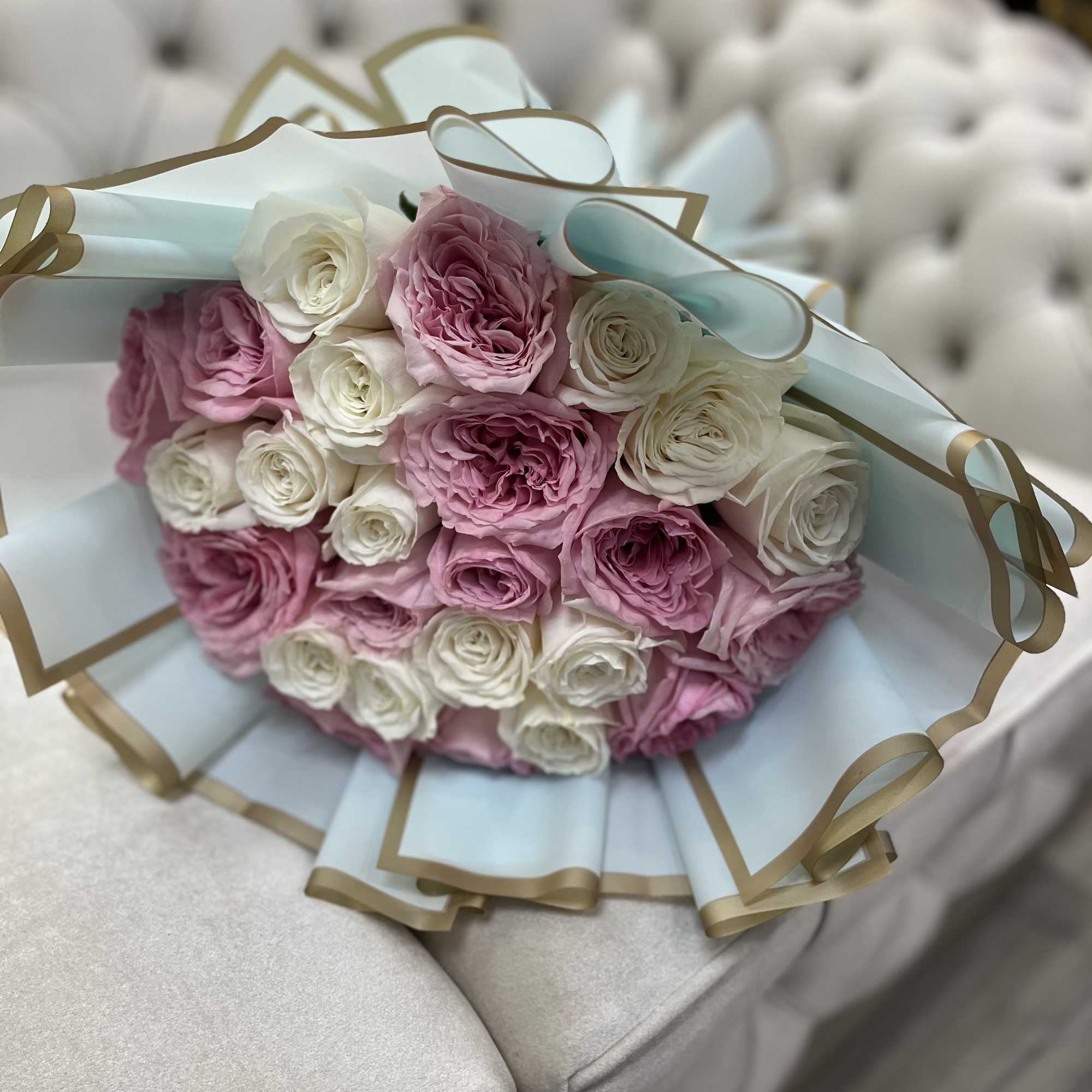 A delicate bouquet of 25 white and blush roses, symbolizing purity, love