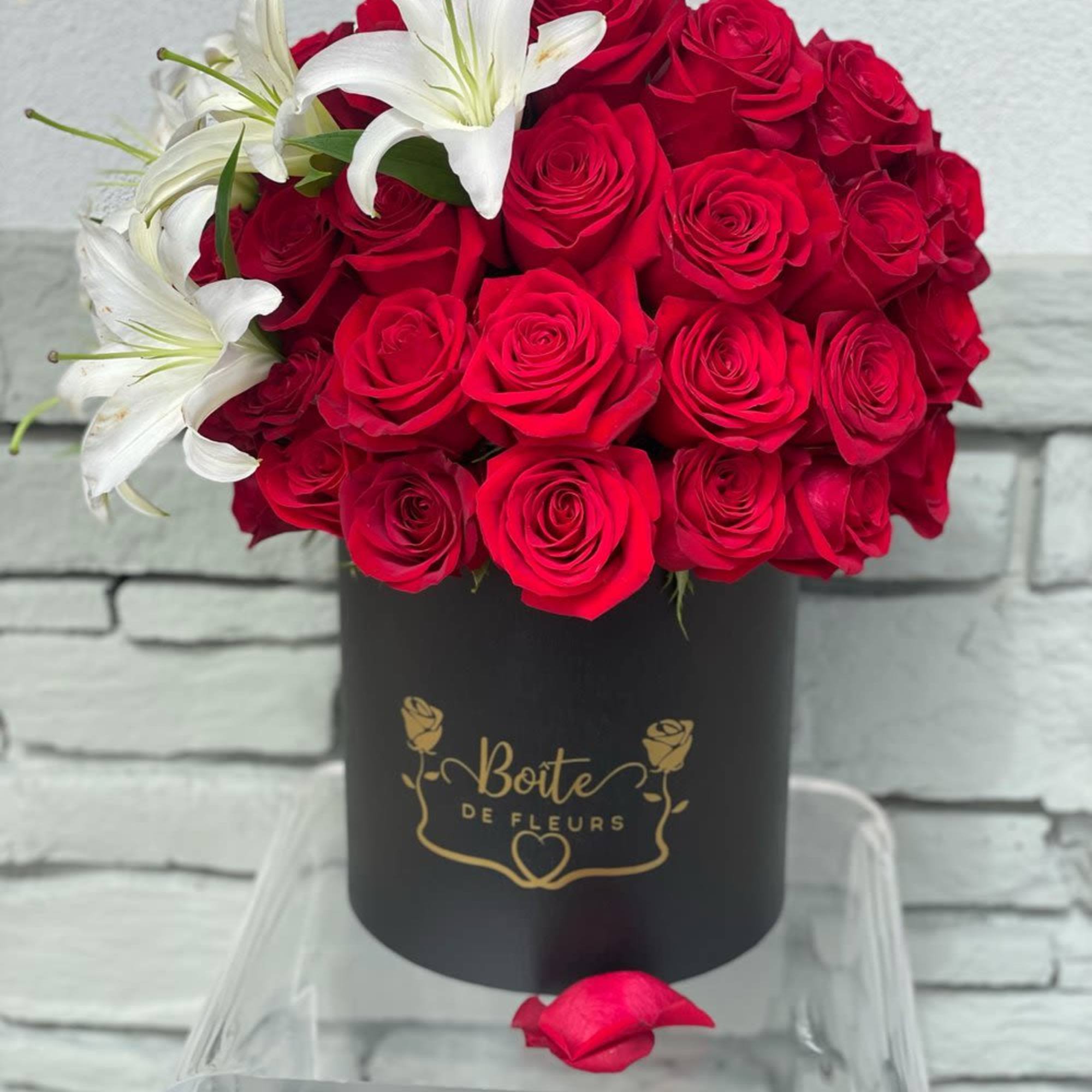 Red roses with white lilies in a black hat box