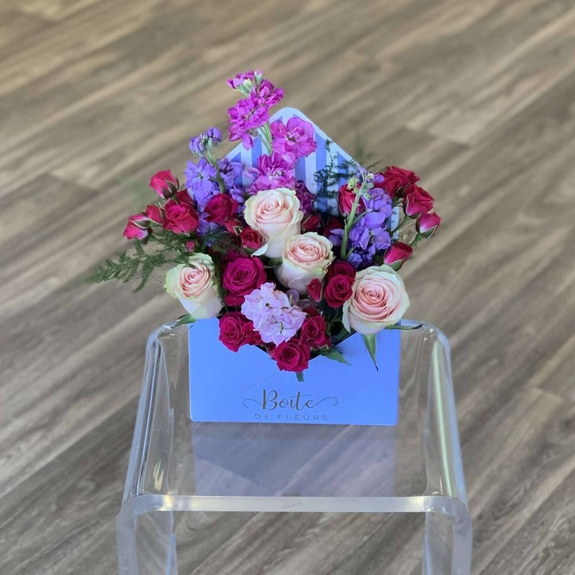 Mixed pink and purple roses arranged in a blue box
