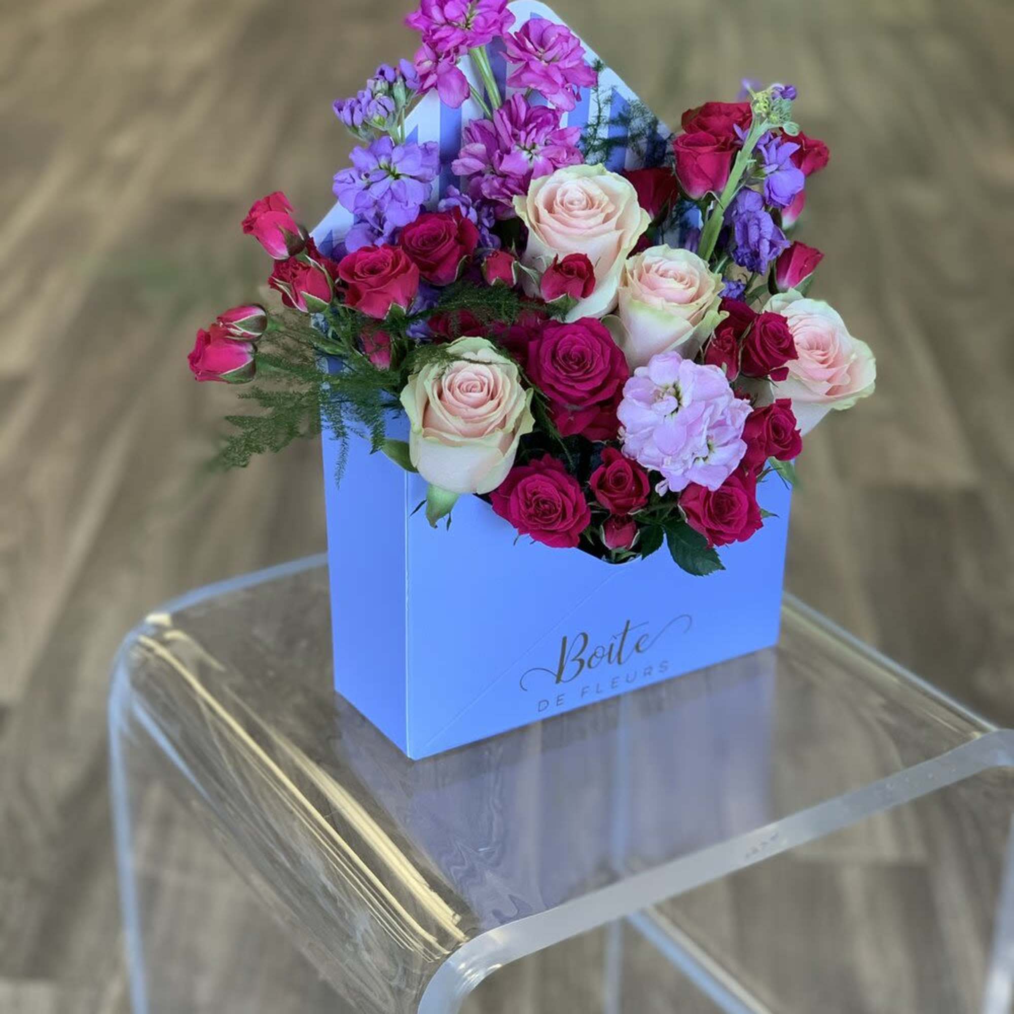 Pink and lavender roses arranged in a blue gift box
