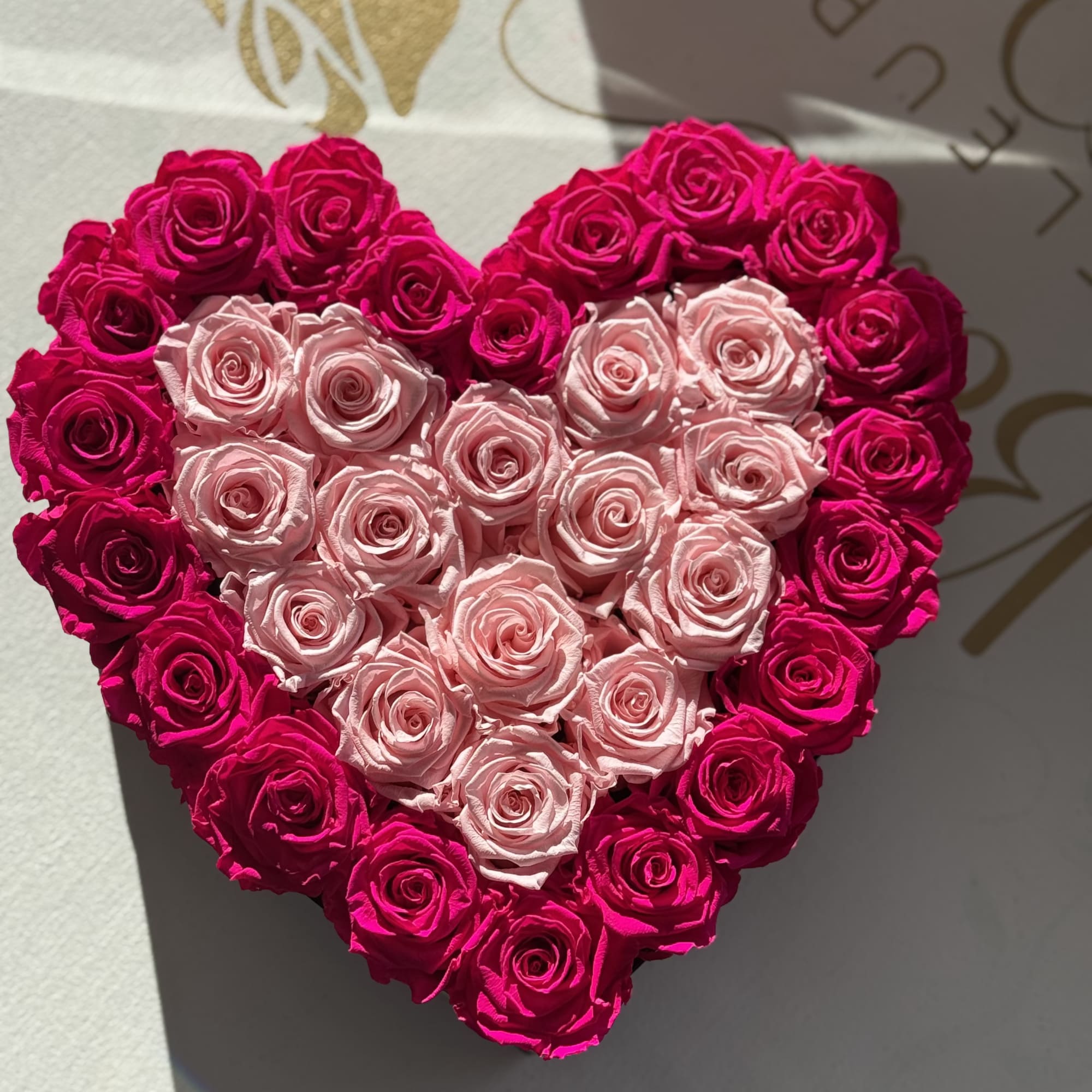 Heart-shaped arrangement of pink and hot pink roses