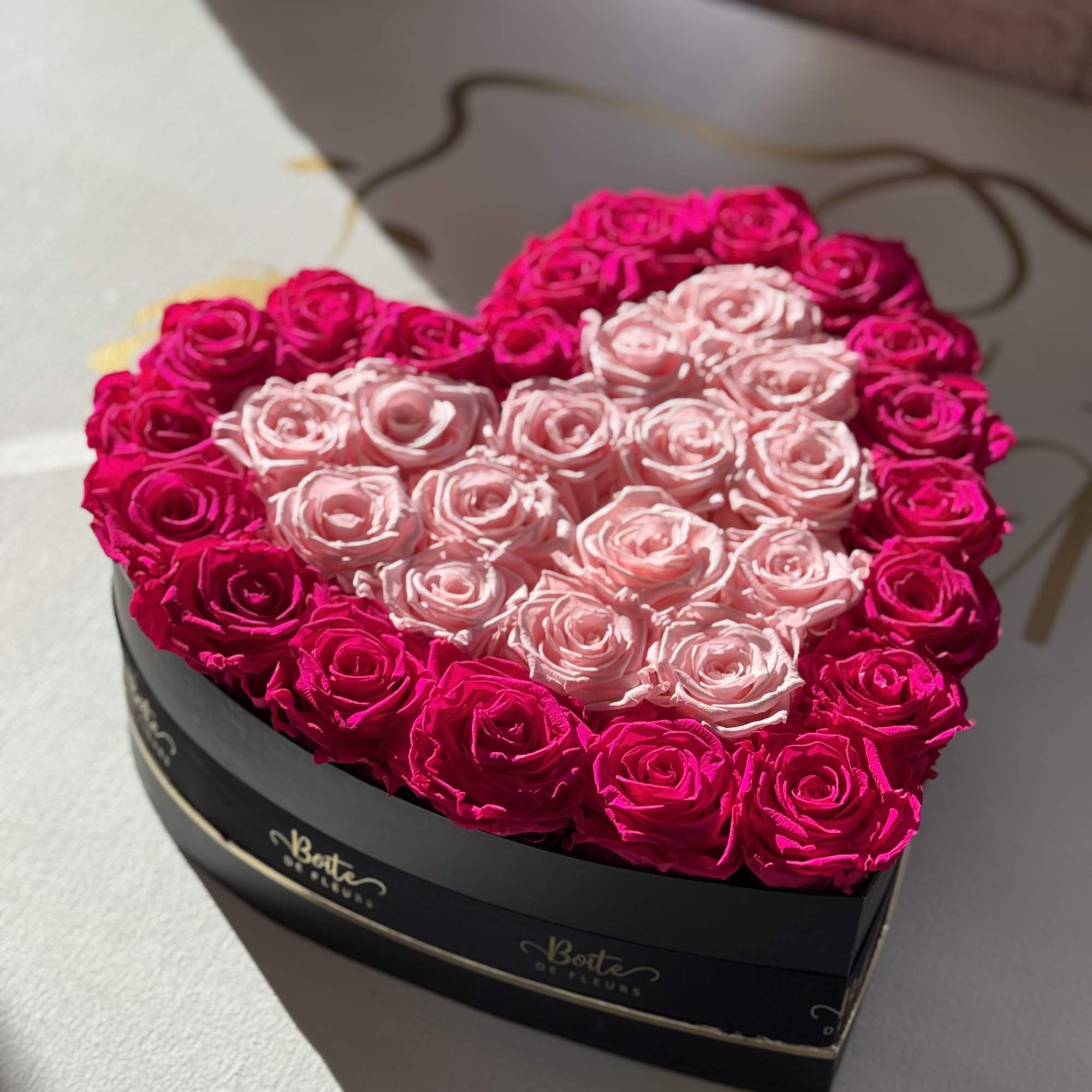 Heart-shaped box filled with pink and hot pink roses