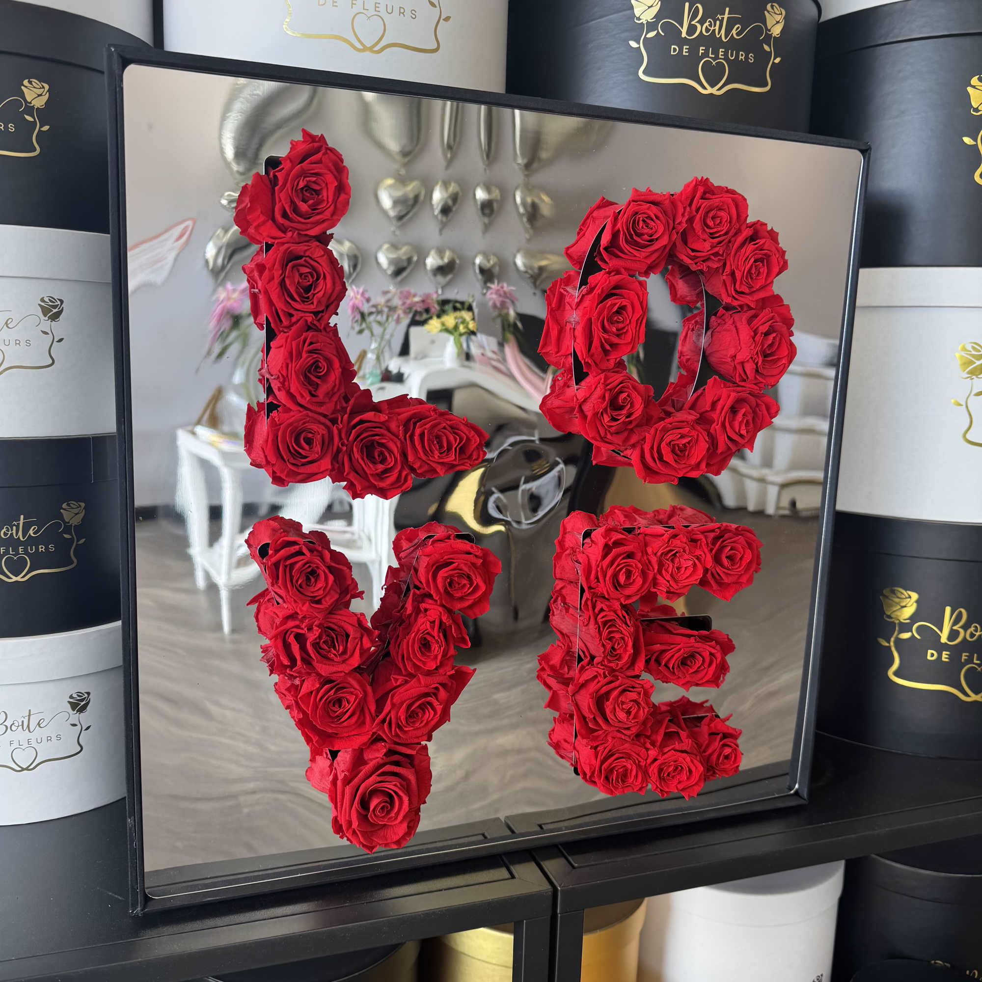 Red roses arranged to spell LOVE in a framed display
