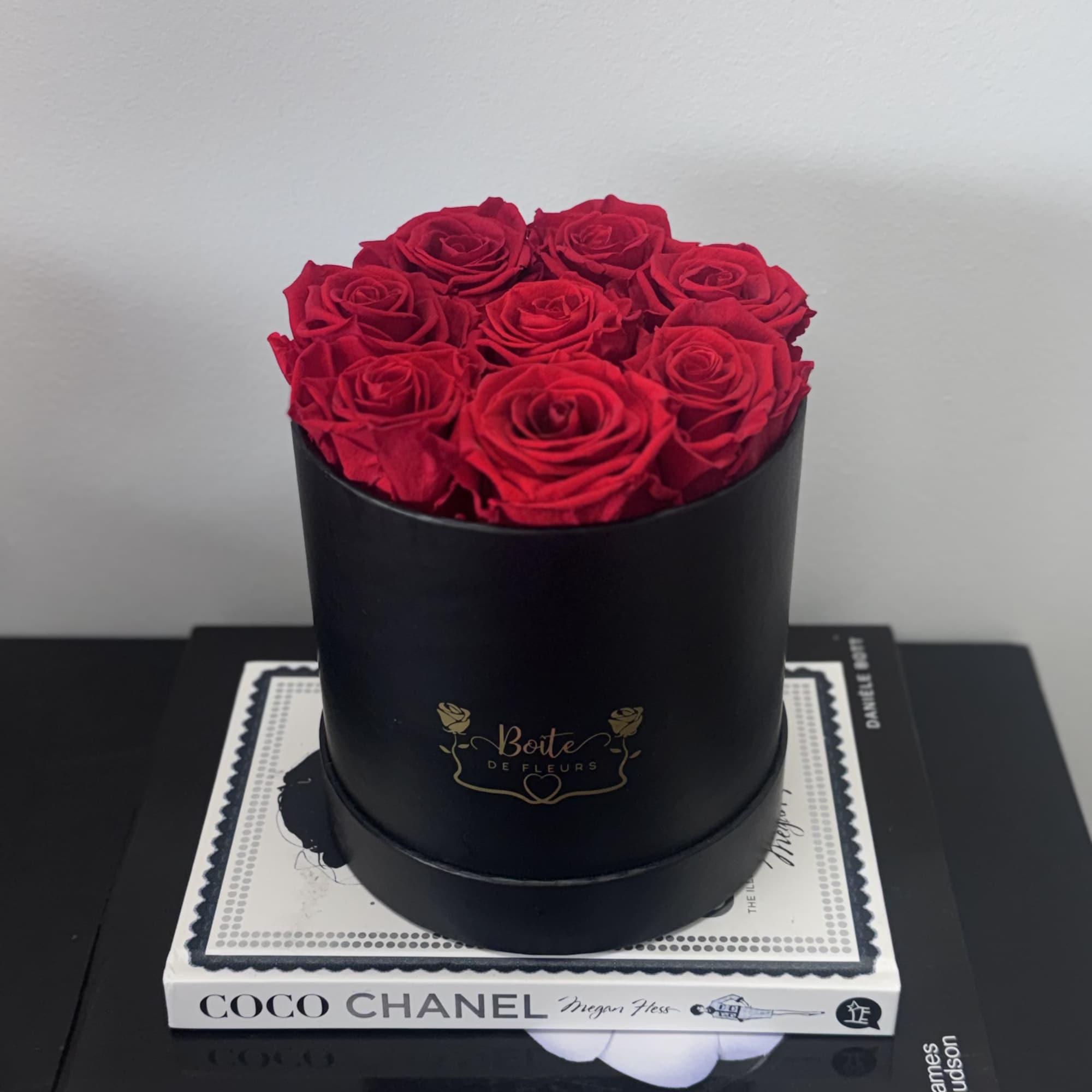 Red roses arranged in a black round box