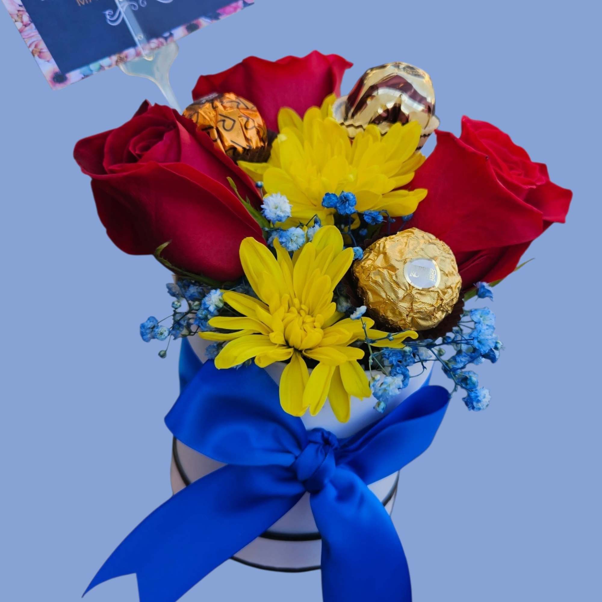 Deep red roses mingle with bright yellow daisies and tiny blue filler