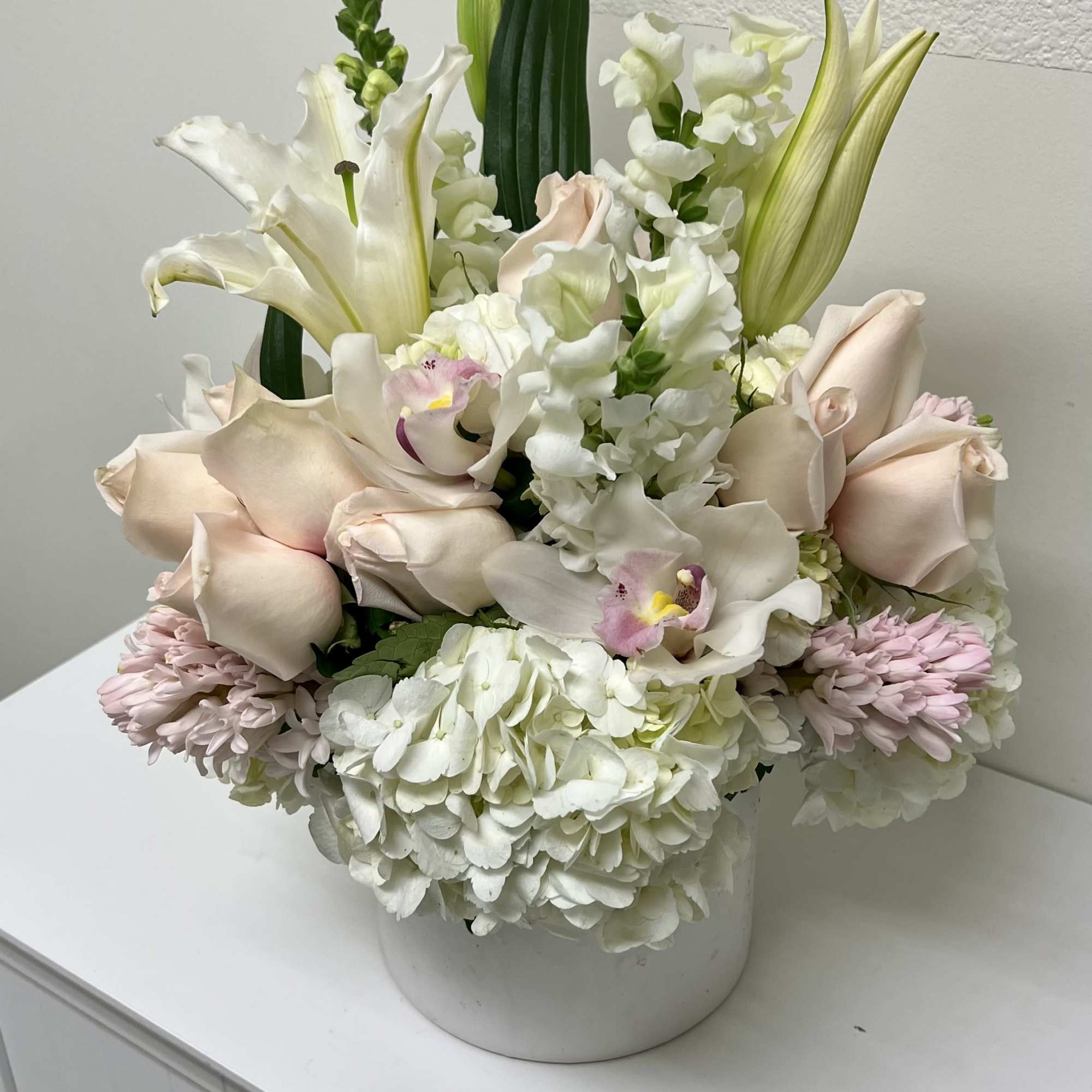 Soft, airy white hydrangeas and blush roses form the heart of this, photo 2 of 2