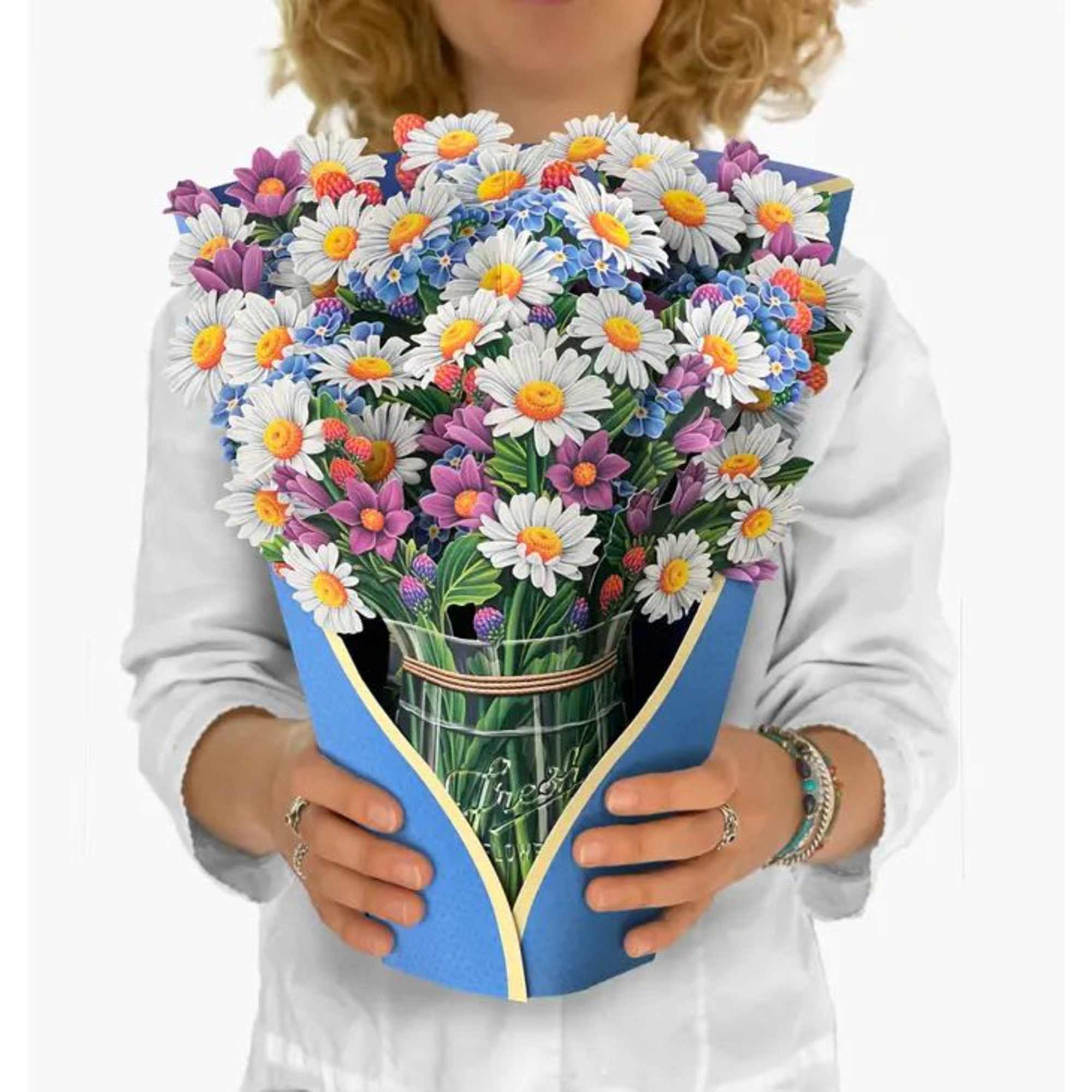 Bouquet of white daisies and purple flowers wrapped in blue paper