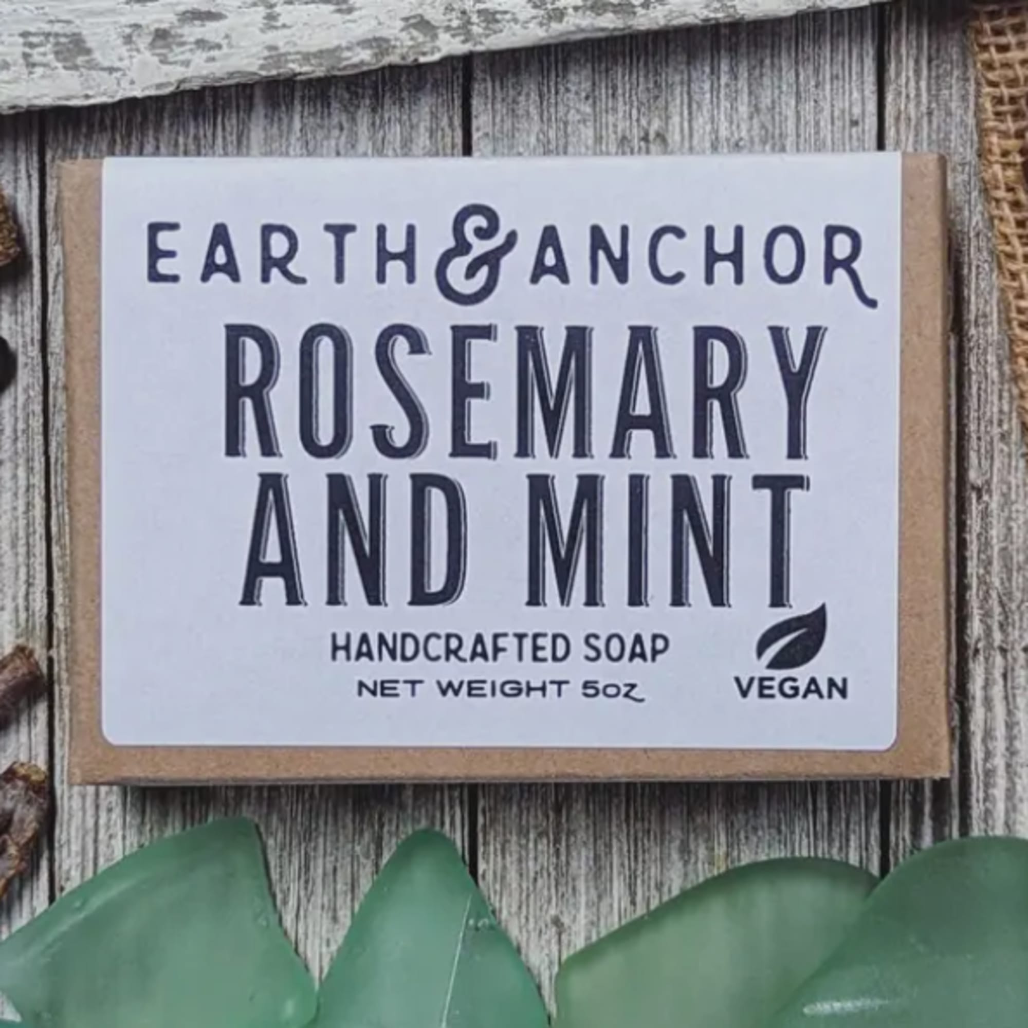 Bar of handcrafted rosemary and mint soap on a rustic wooden surface