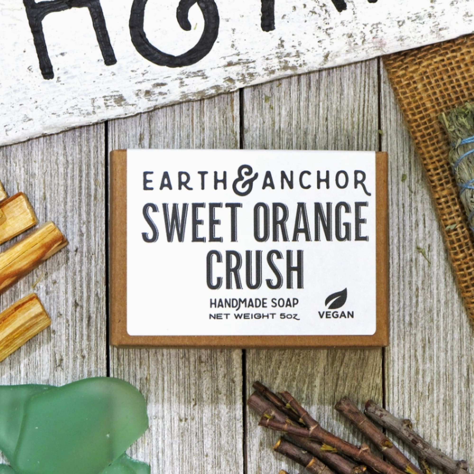Boxed handmade soap labeled Sweet Orange Crush on a rustic wood surface