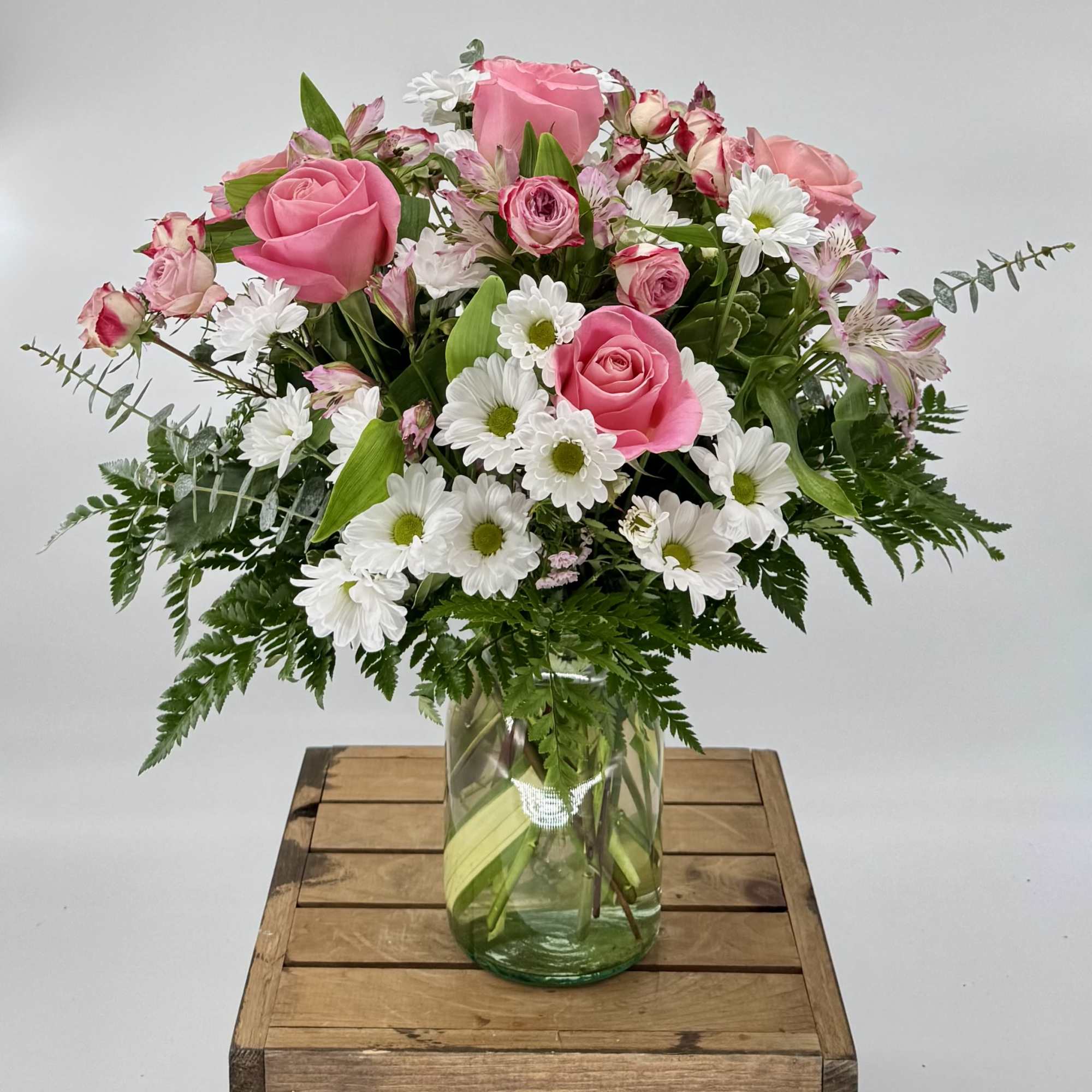 Pink roses and white daisies in a glass vase