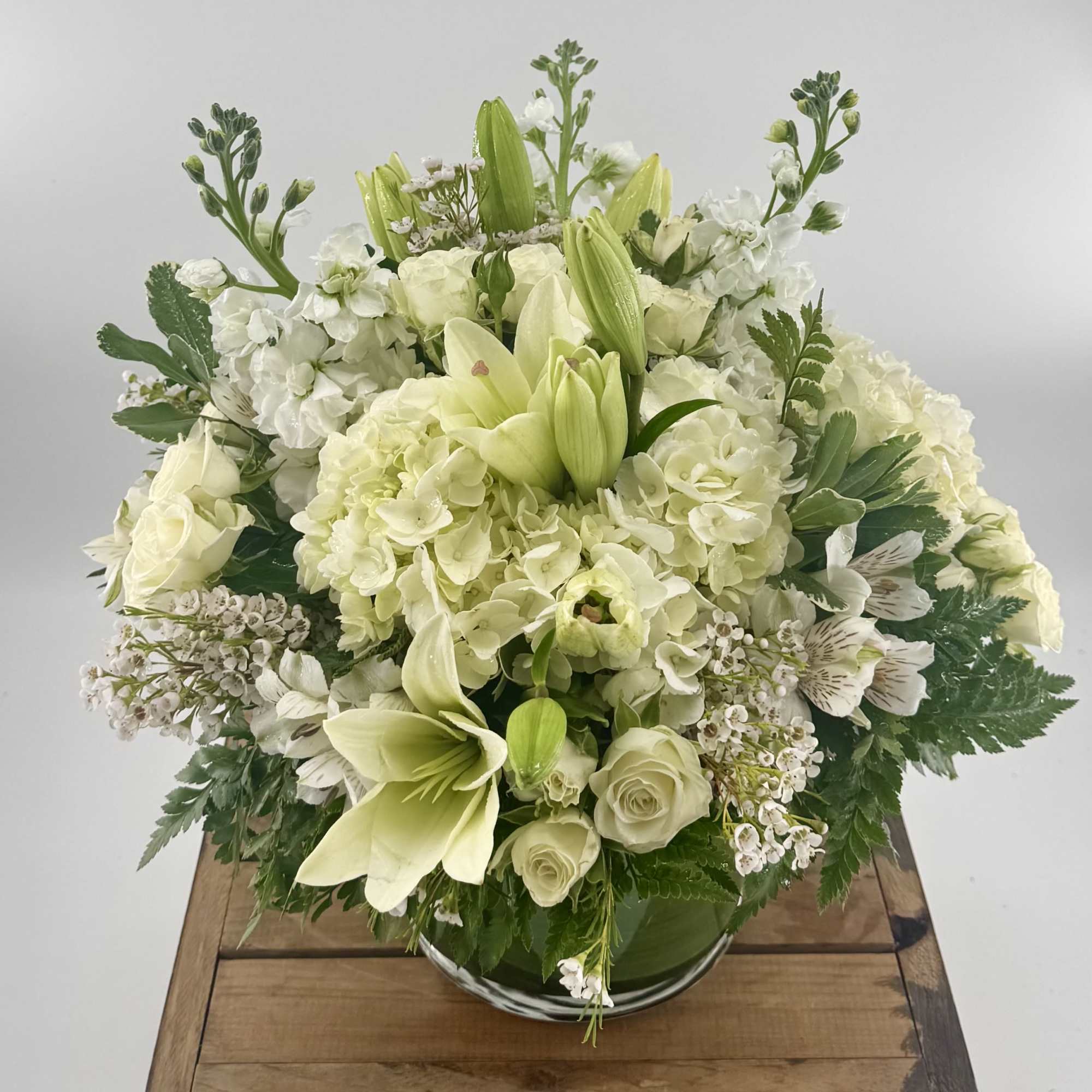 White and pale green floral arrangement in a glass bowl