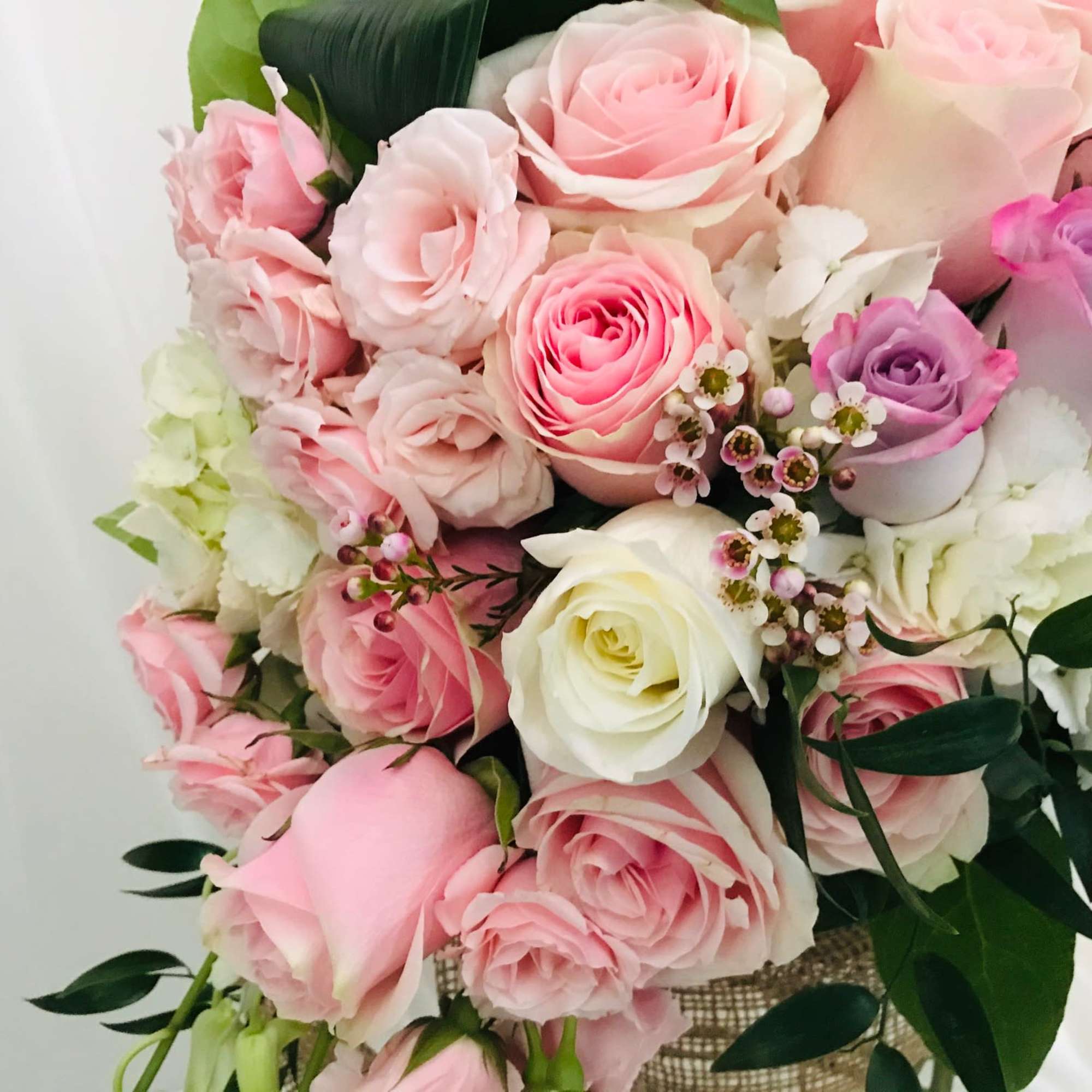 Bouquet of pink, white, and lavender roses with small white filler flowers