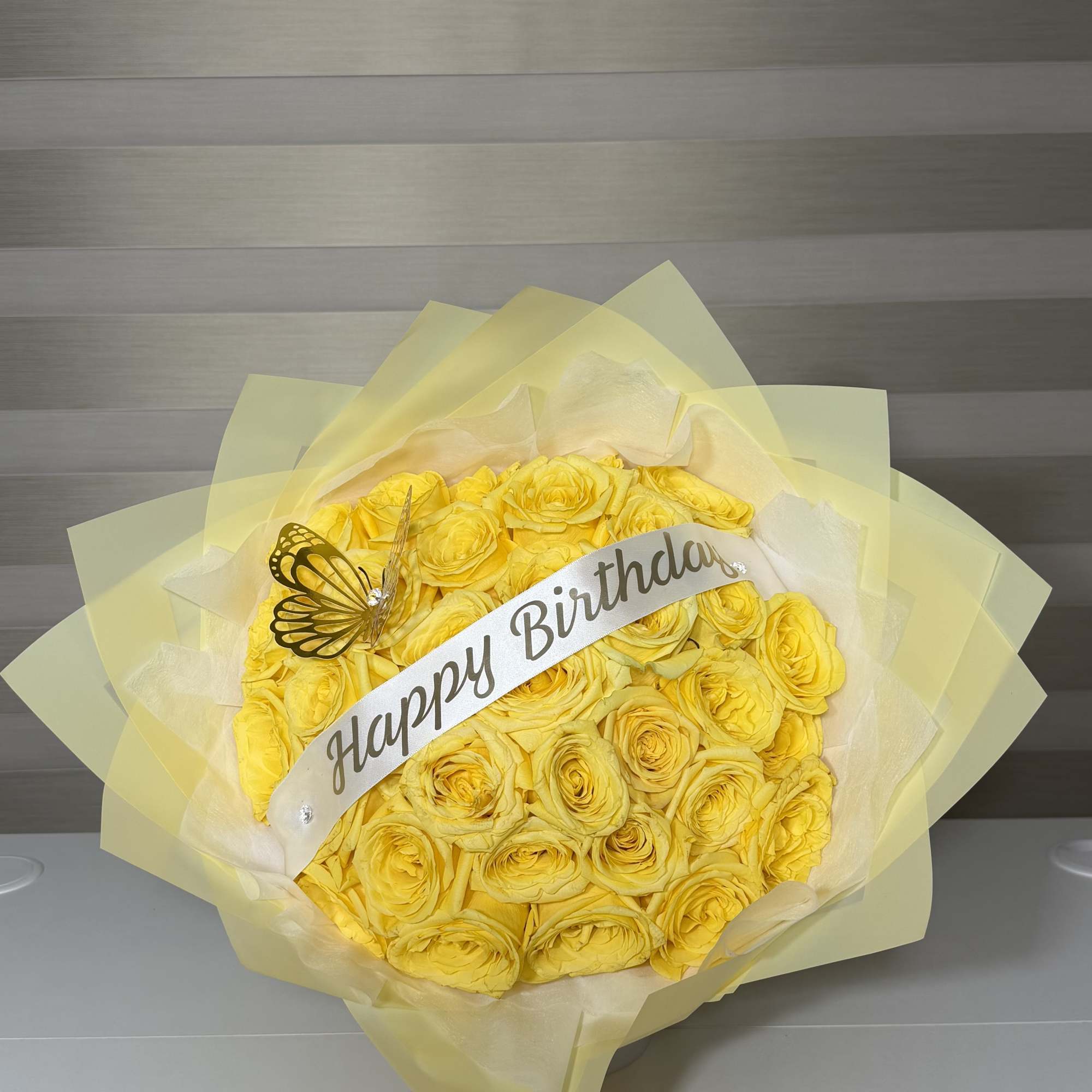 Yellow rose bouquet with a Happy Birthday ribbon and butterfly decoration