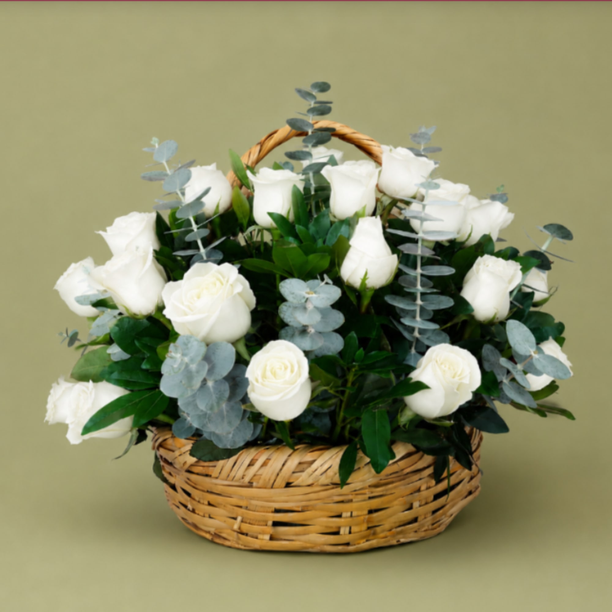 Pure white roses gathered low in a woven wicker basket create a