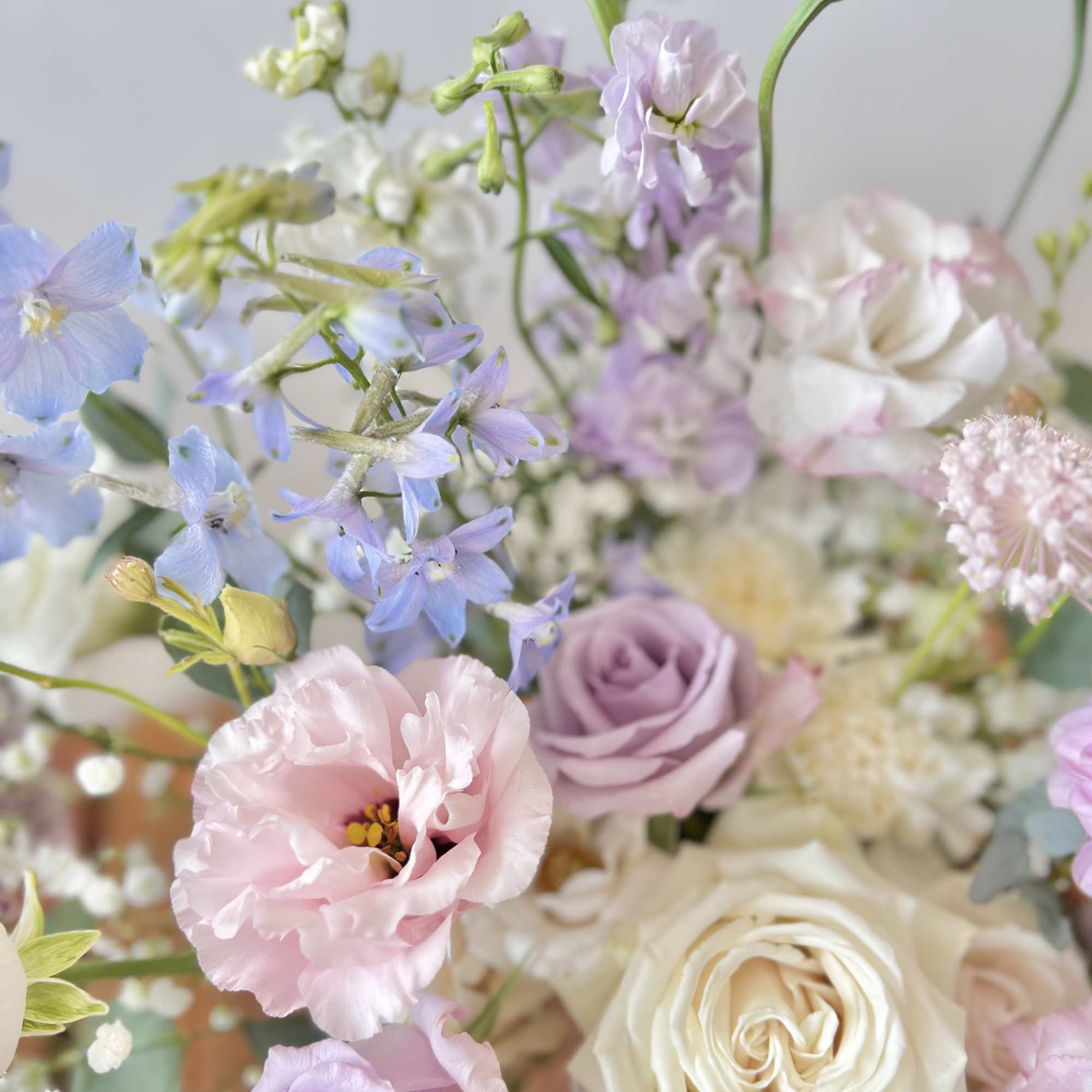 Pastel bouquet with roses, pink blooms, and blue flowers