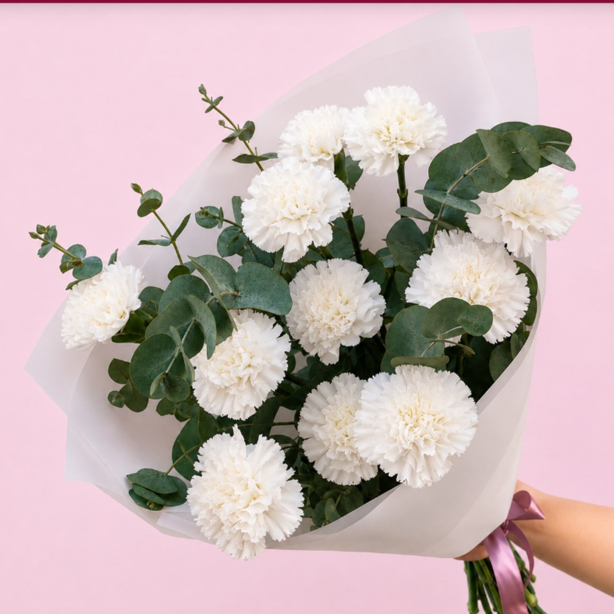 Bouquet of white carnations with eucalyptus wrapped in pale paper