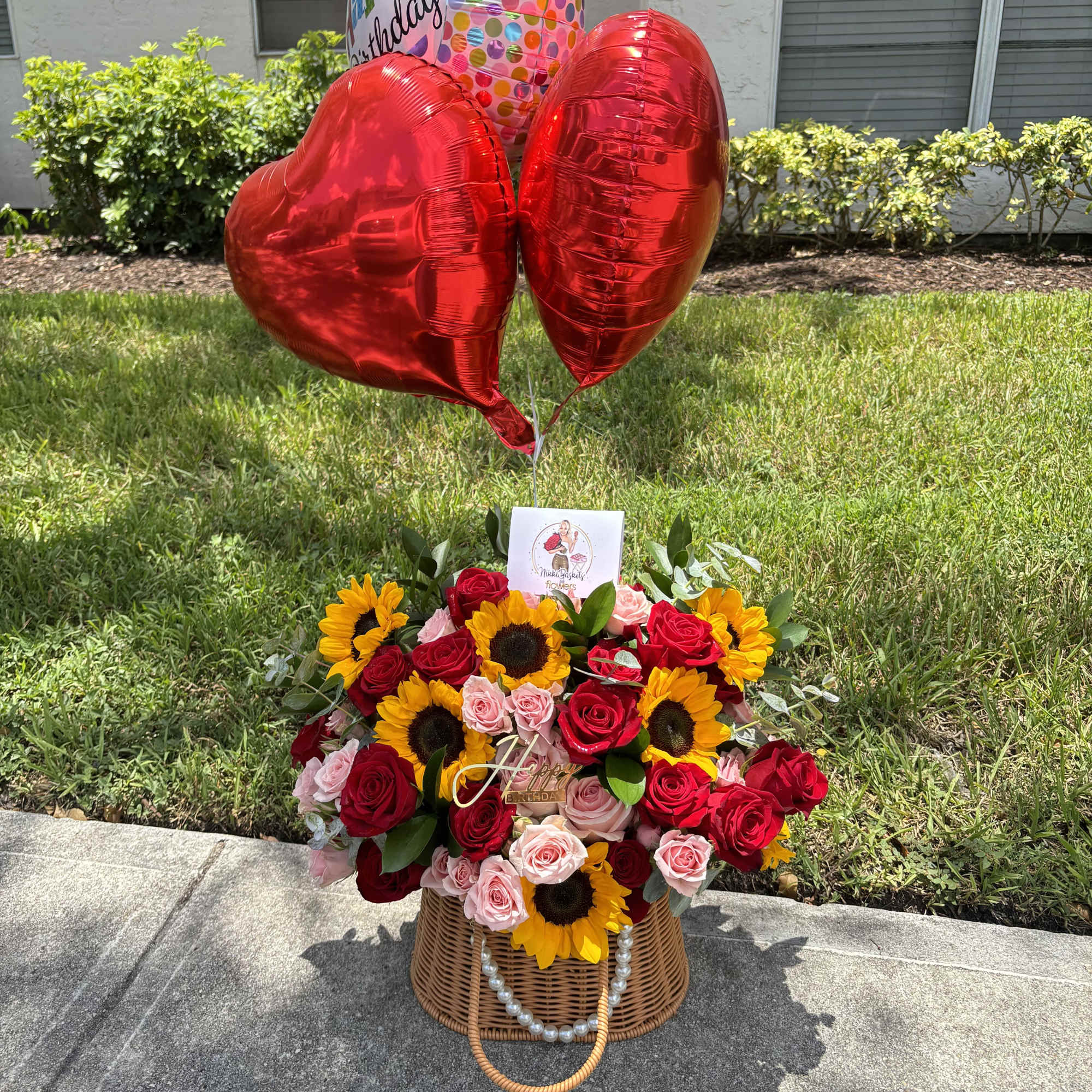 Basket arrangement of red roses and sunflowers with birthday balloons