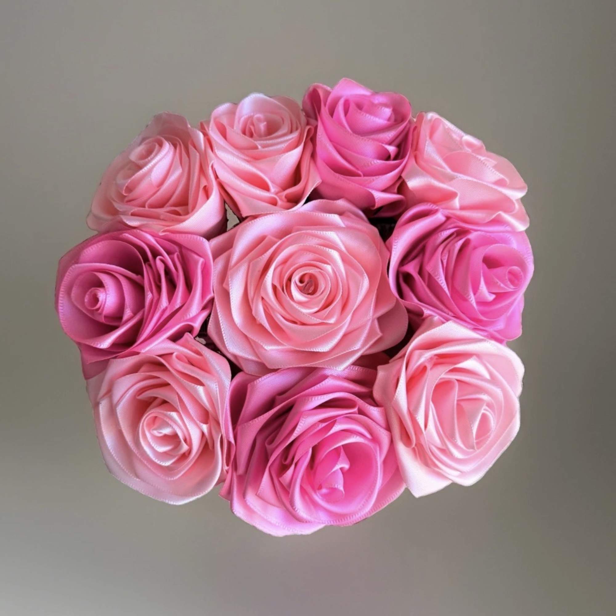 Bouquet of pink satin roses arranged in a round cluster