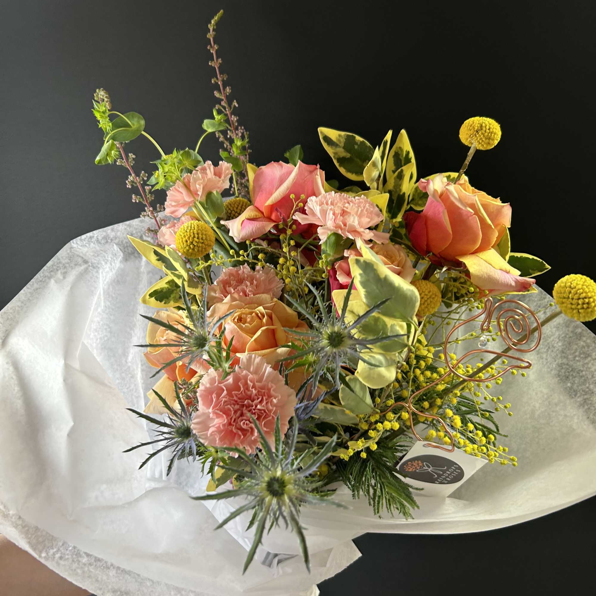 Bouquet of peach roses and pink carnations with yellow accents