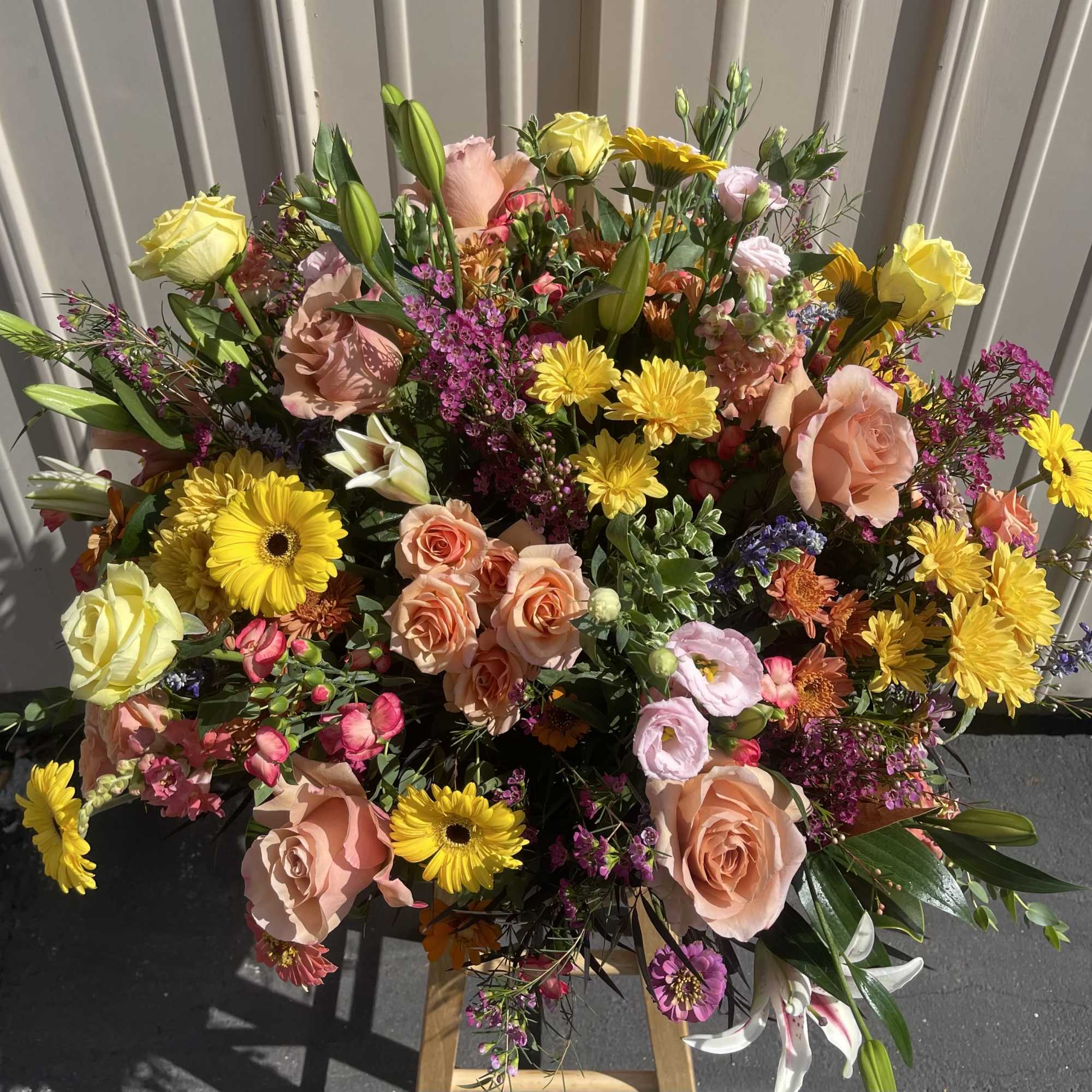 Large mixed bouquet with pink roses, yellow daisies, and lilies
