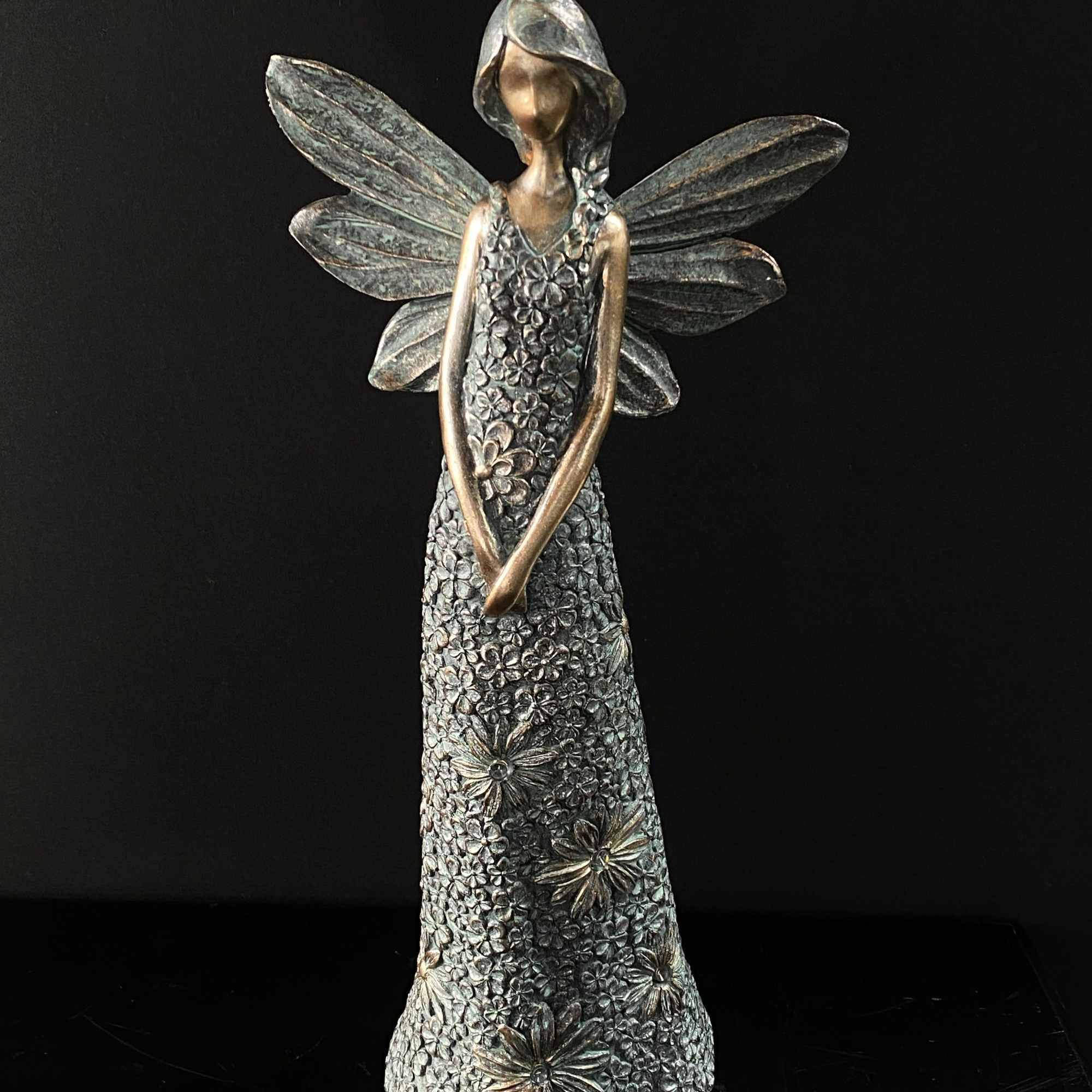 Decorative angel figurine with metallic wings and floral-textured dress