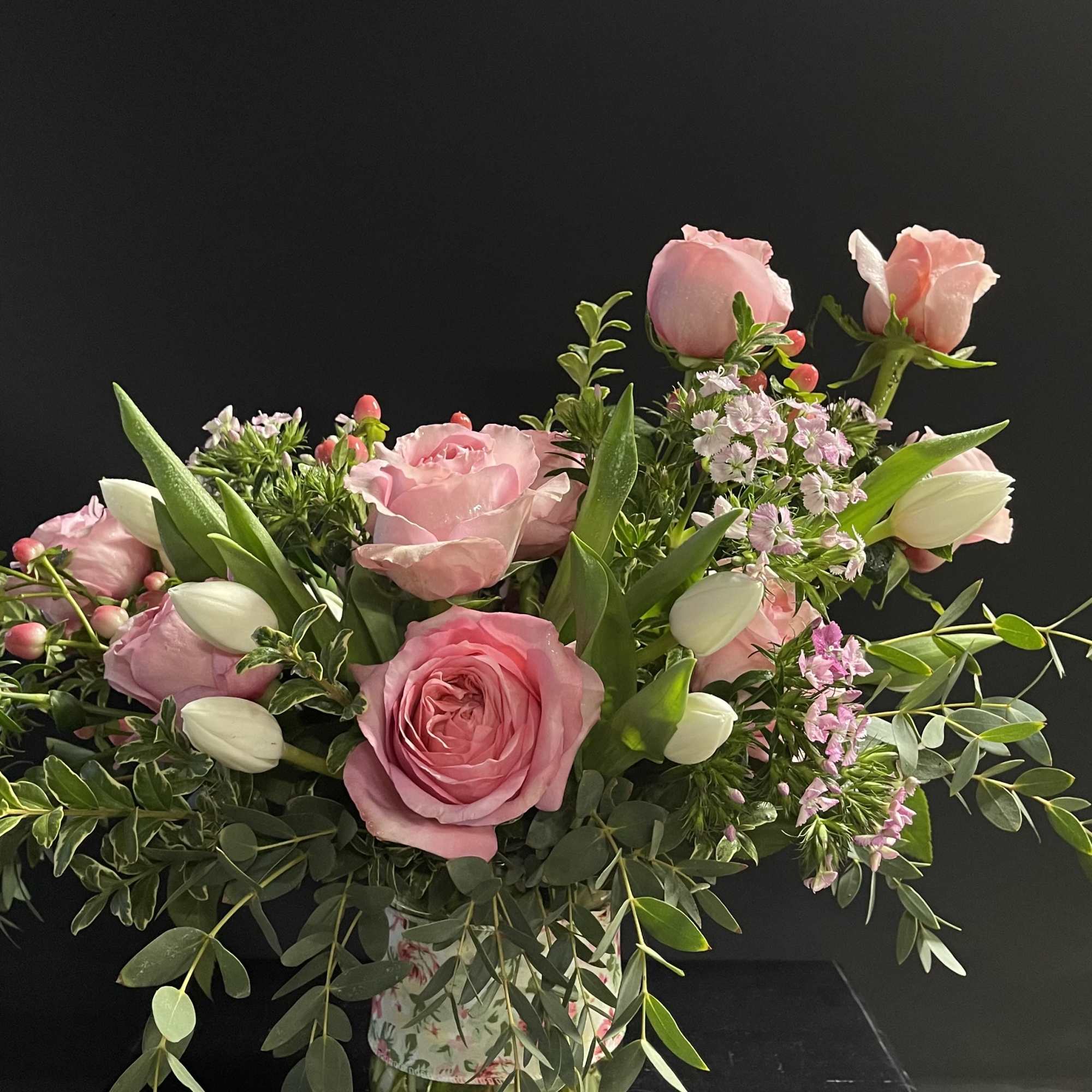 Pink roses and white tulips arranged in a floral vase
