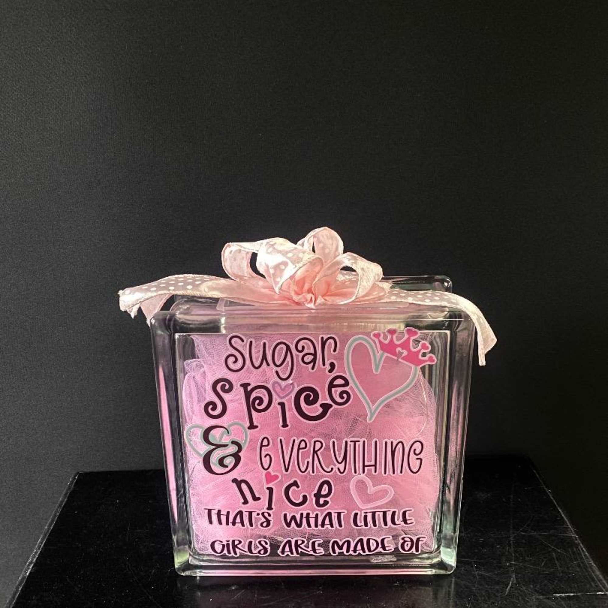 Pink gift box with a ribbon and the words "Sugar, spice & everything nice"