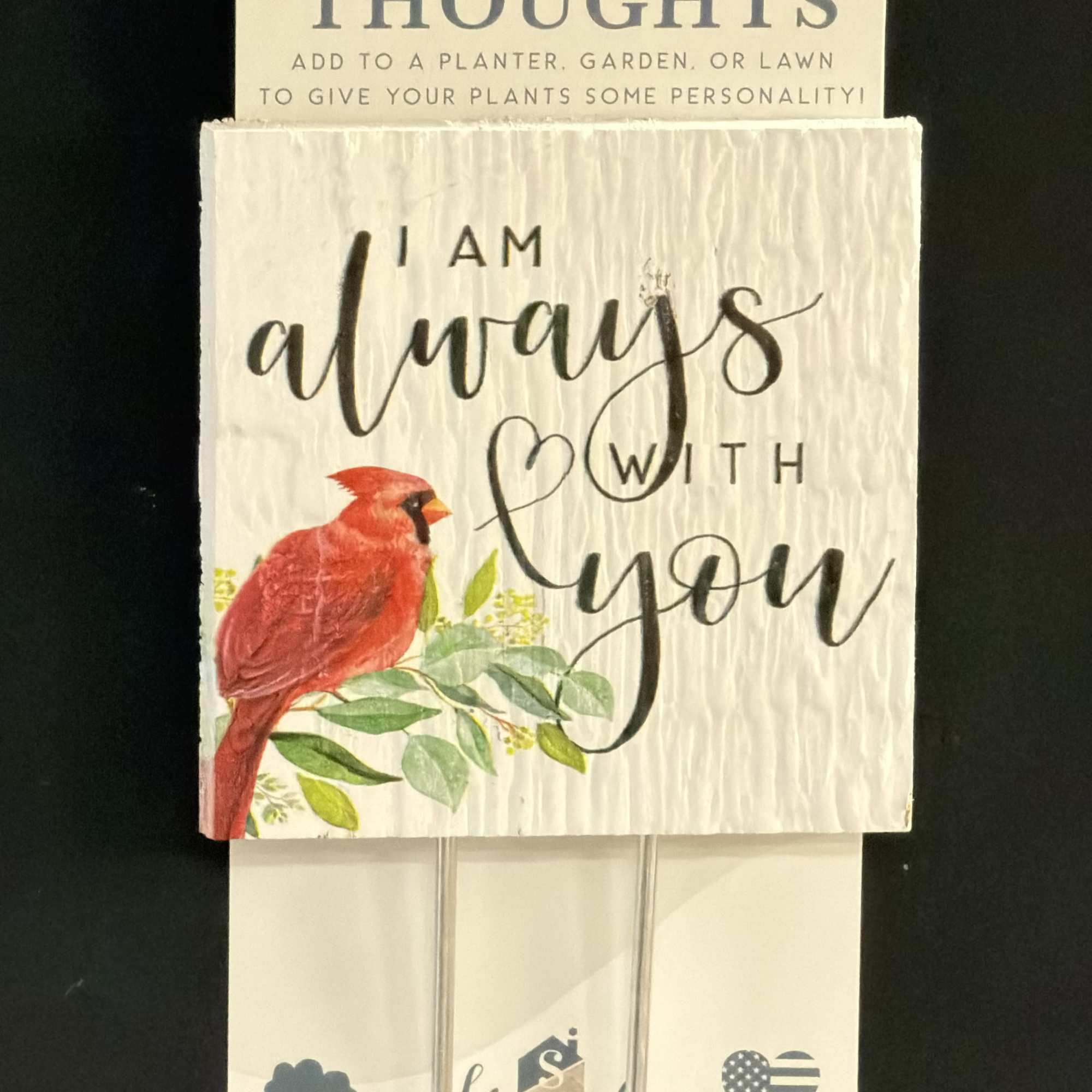 Two plant stakes with text and a red cardinal design on a display card.