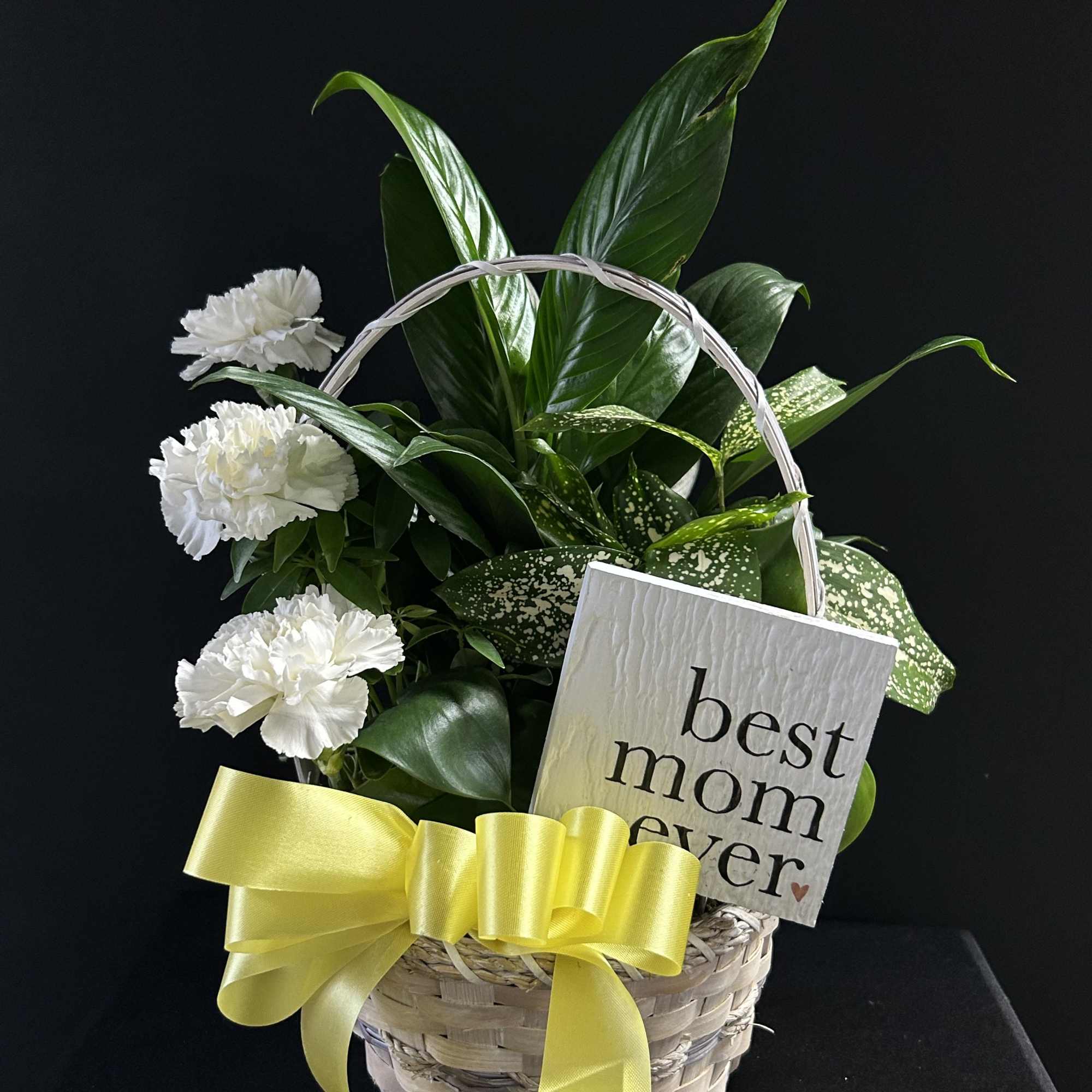 White carnations in a basket with a yellow ribbon and a "best mom ever" sign
