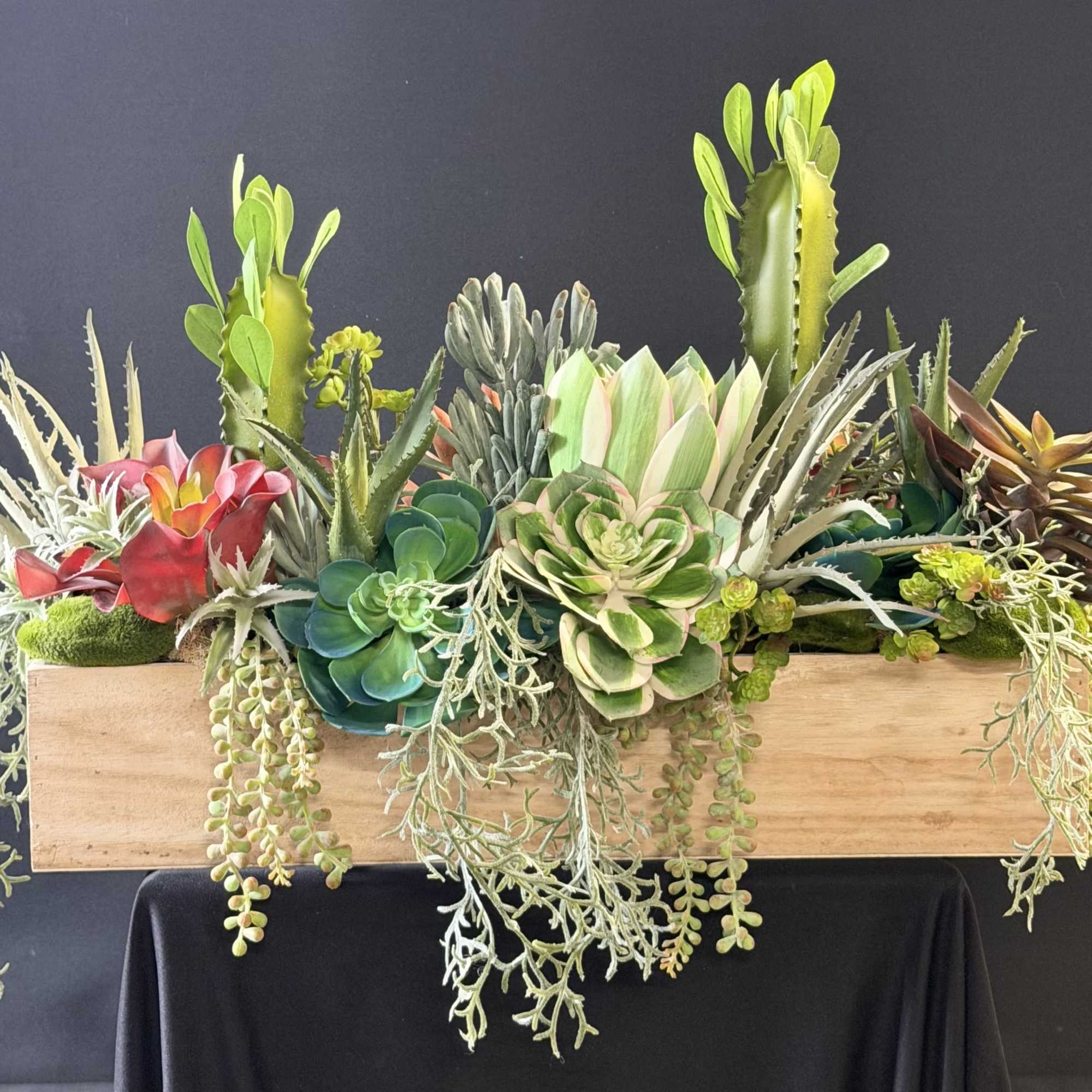 A sculptural mix of faux succulents and cactus-like plants arranged in a