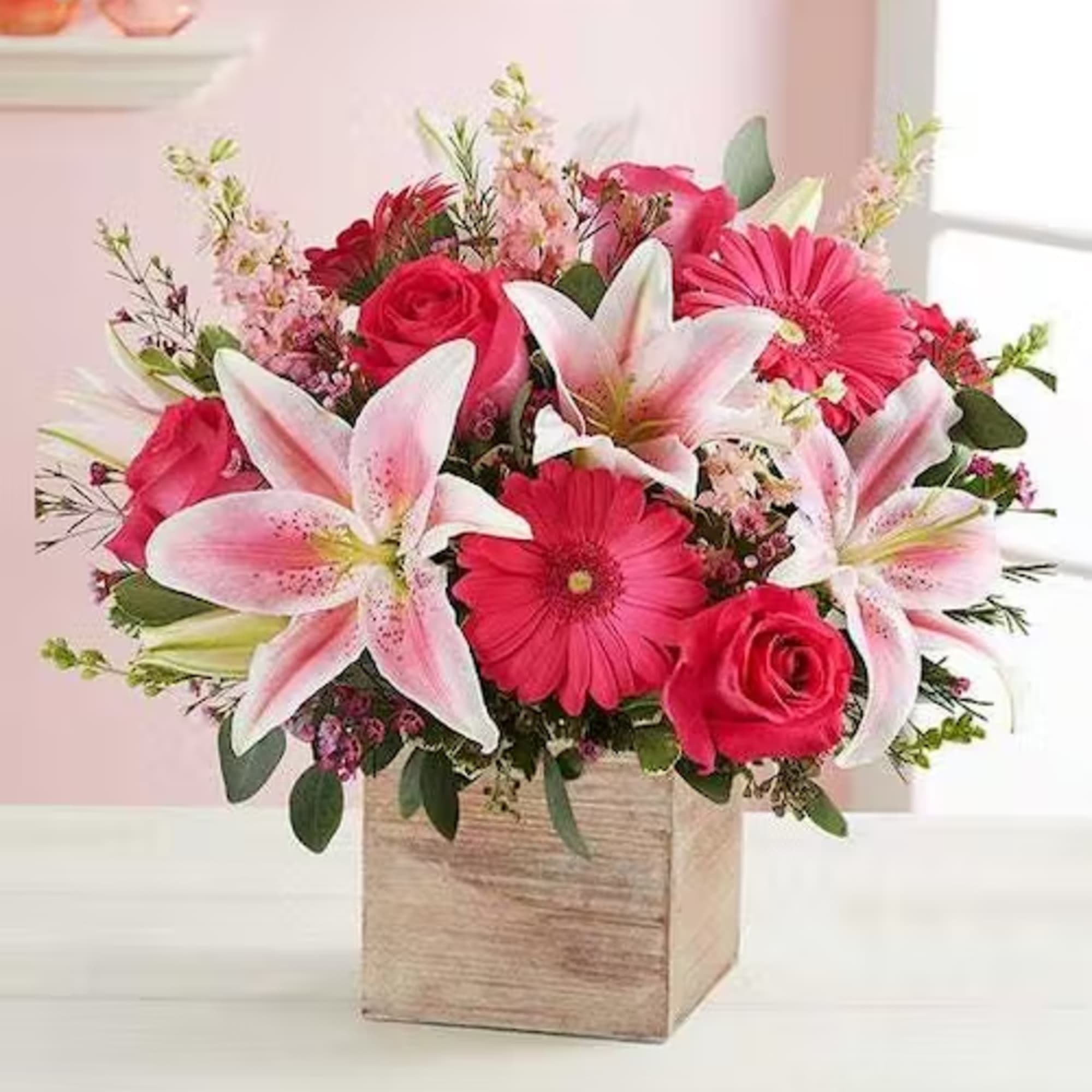 Pink and white bouquet with roses, lilies, and gerbera daisies in a wooden box