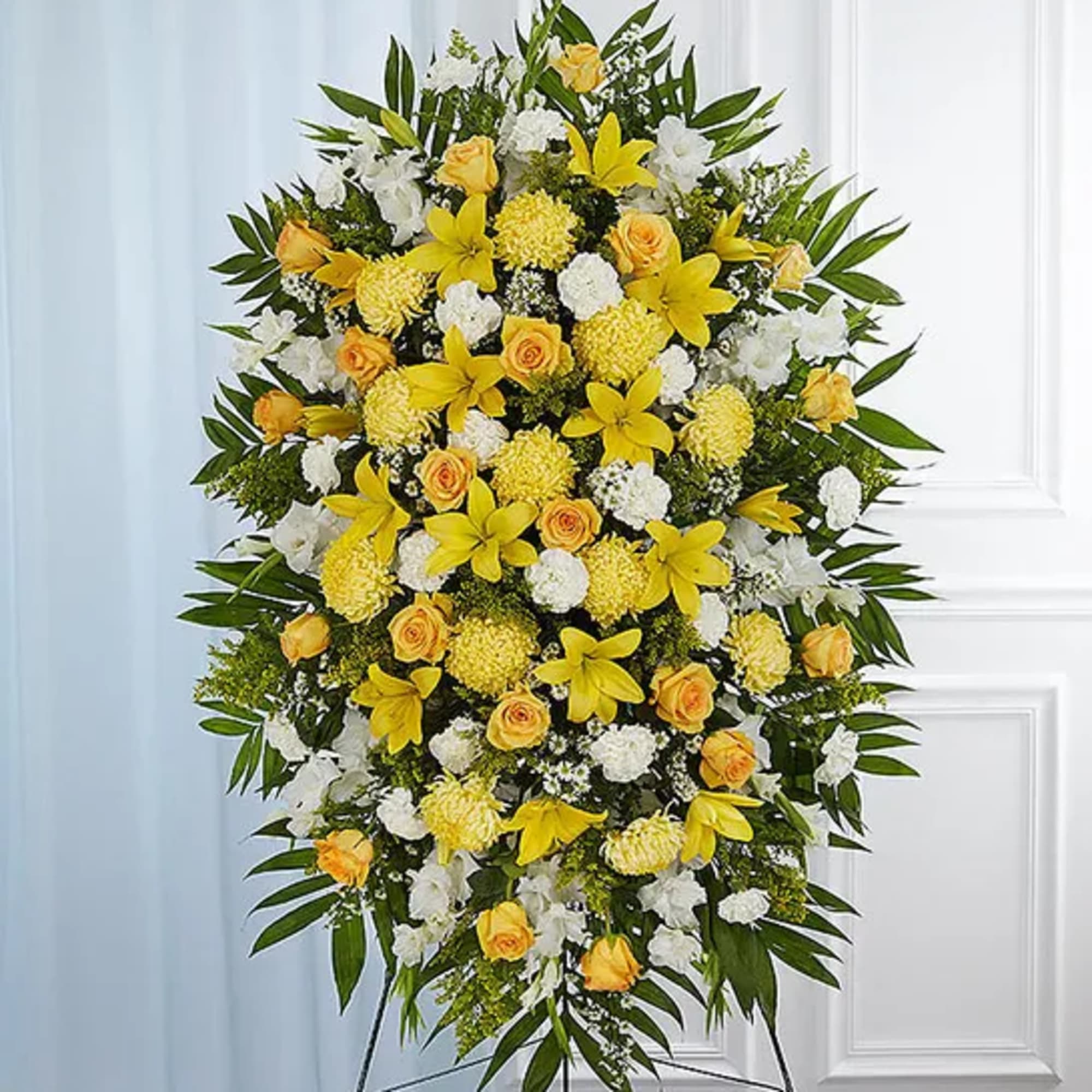 Large standing floral spray with yellow and white flowers on a metal easel