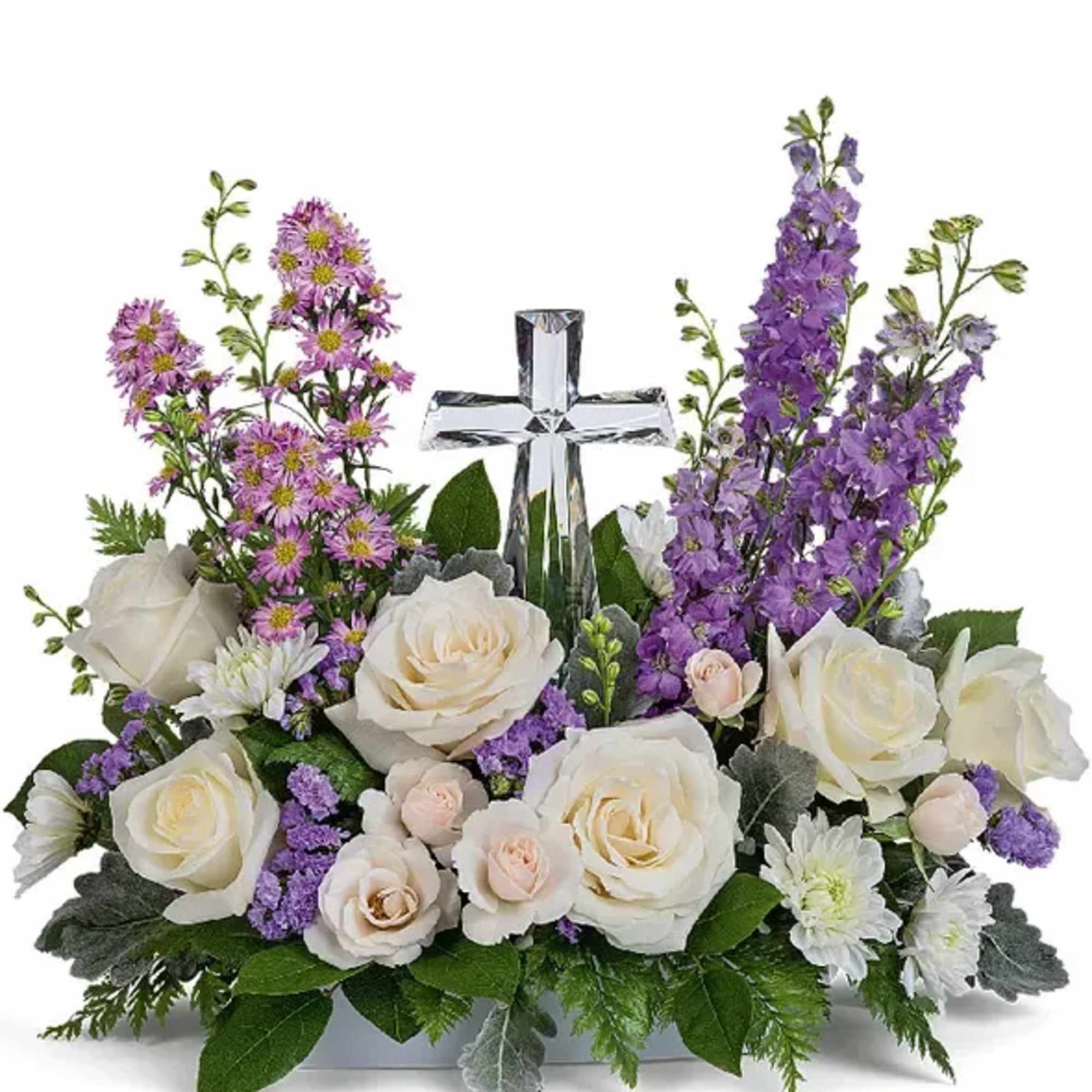 White roses and purple flowers arranged around a clear glass cross
