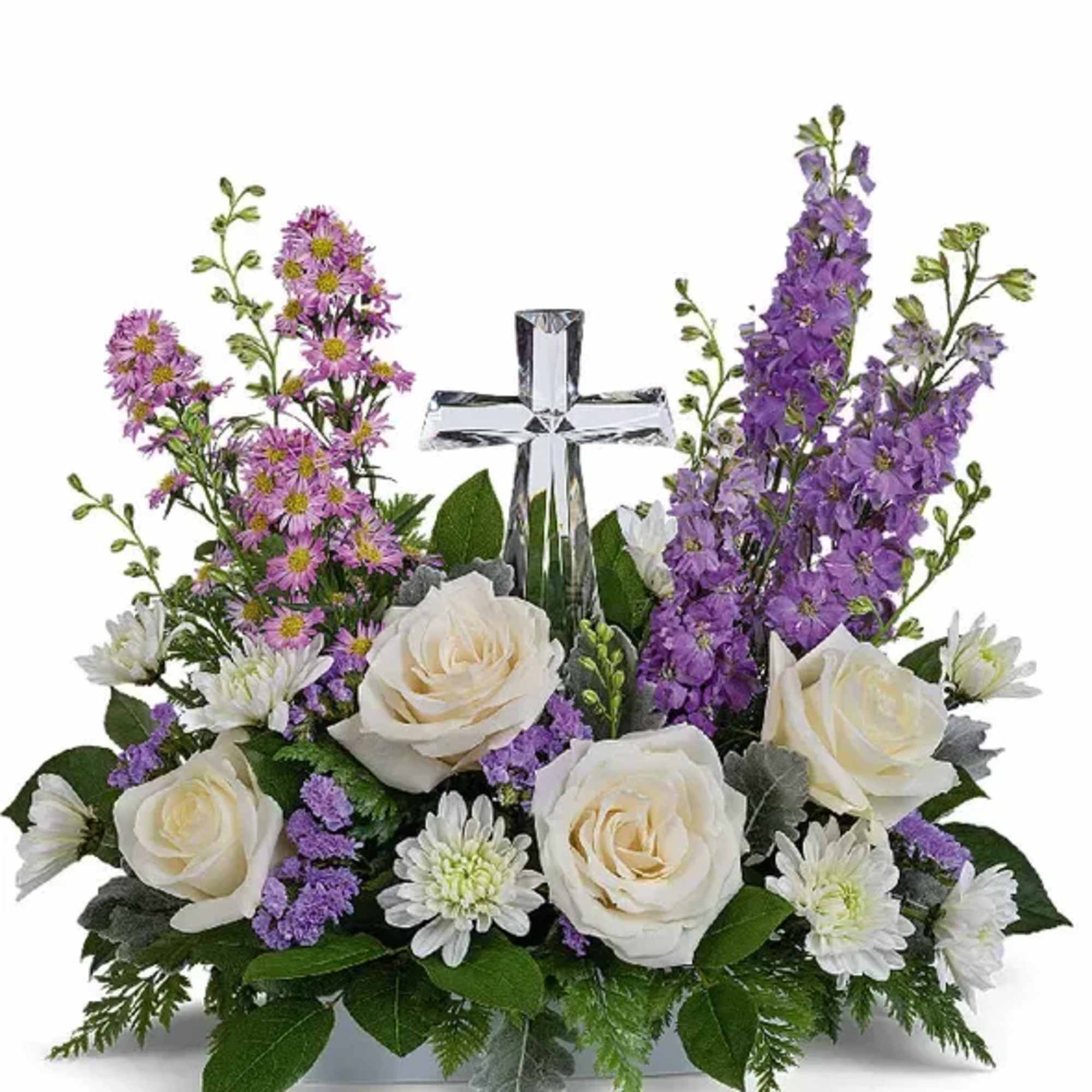 White roses and purple flowers arranged around a clear glass cross