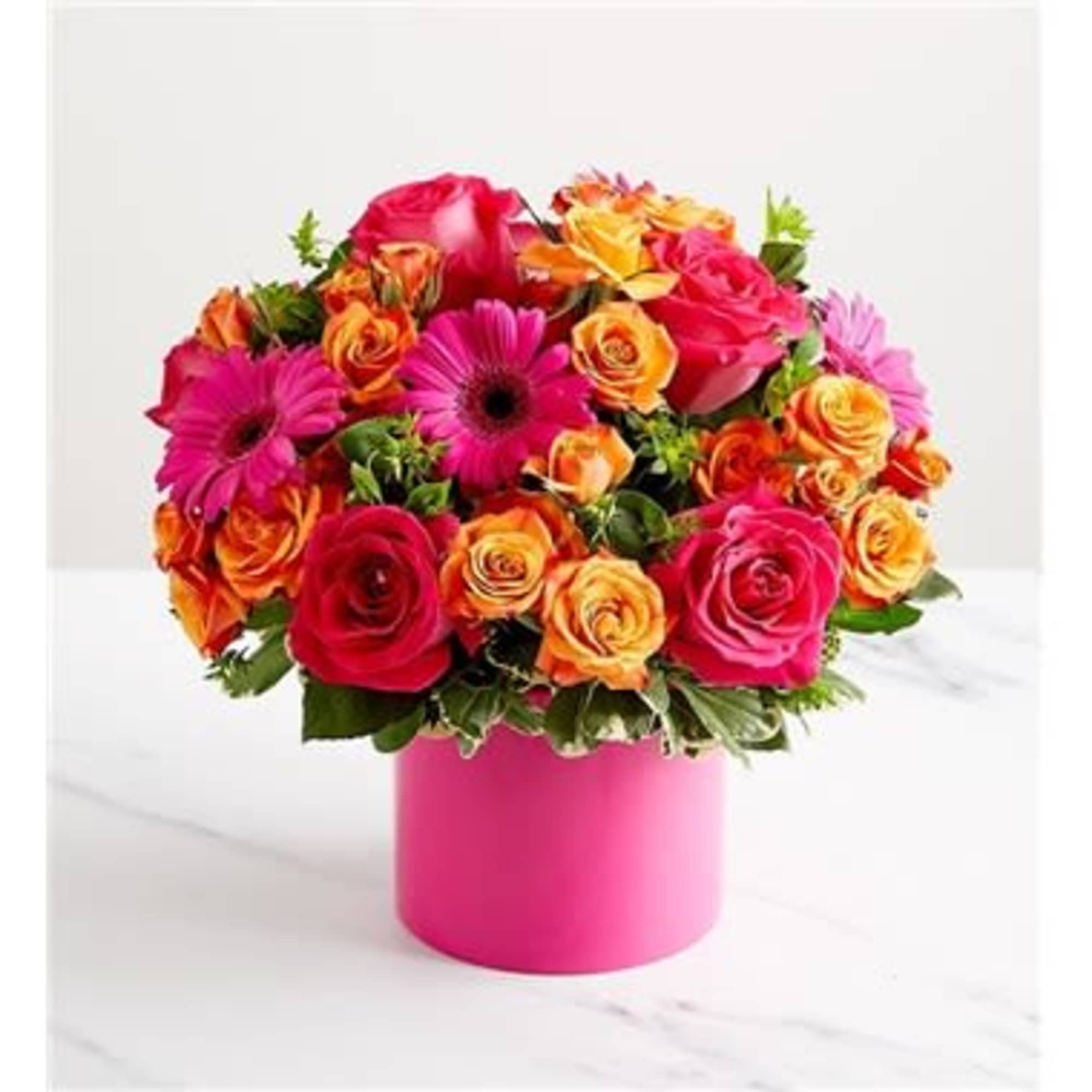 Mixed bouquet of roses and gerbera daisies in a pink vase