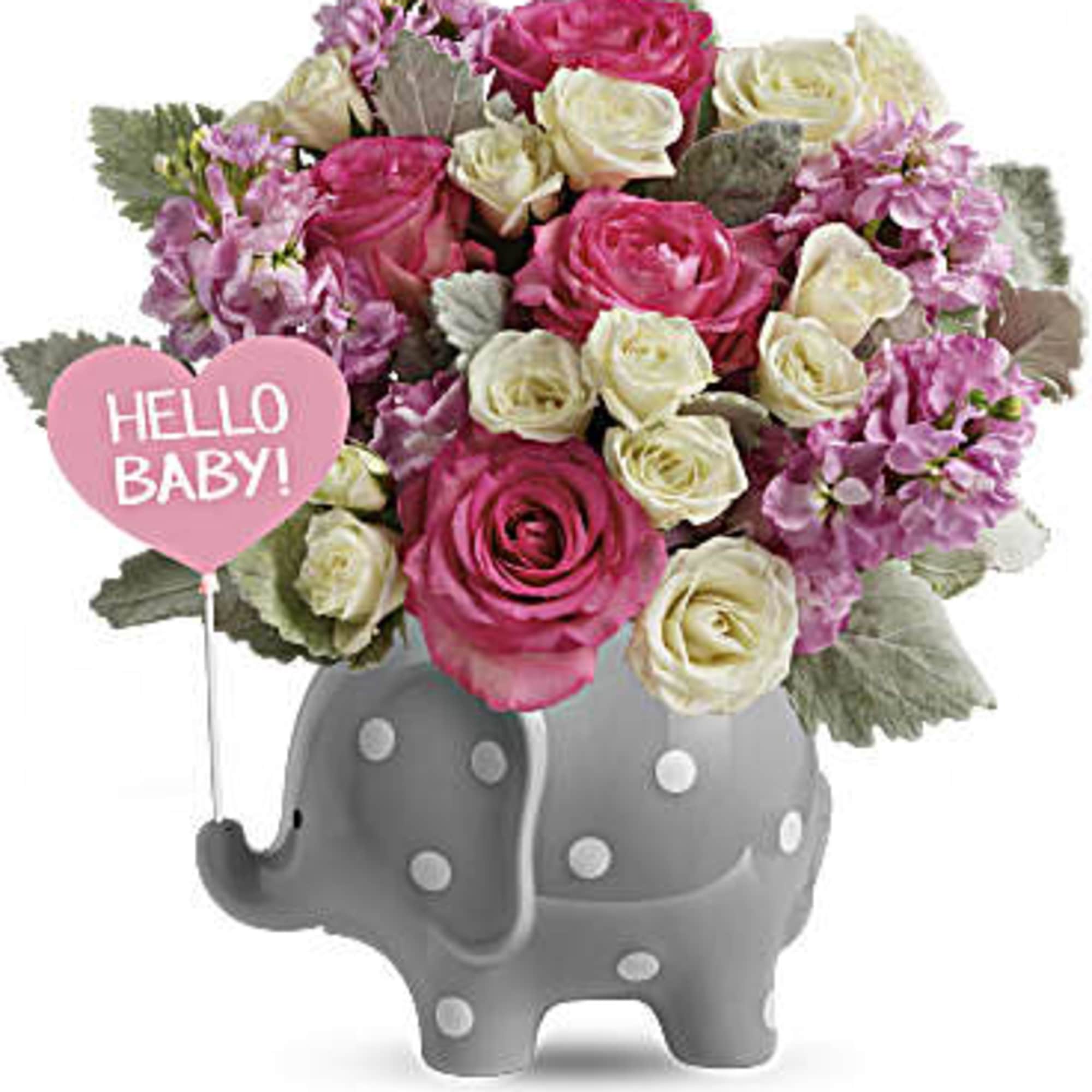 Pink and white rose arrangement with lavender blooms in a gray polka-dot elephant vase with a pink Hello Baby heart pick.