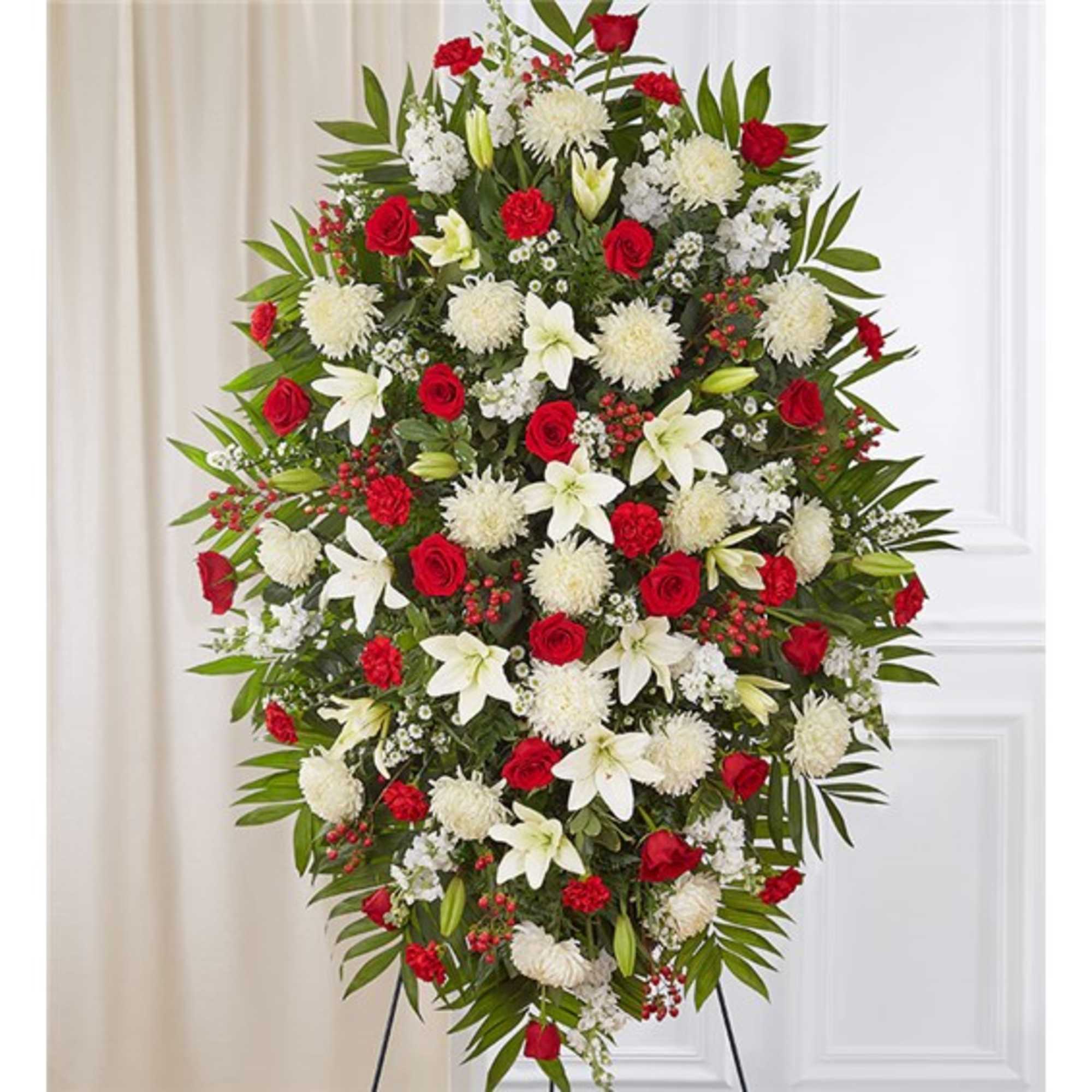 Standing spray of red roses, carnations and white lilies and mums on an easel