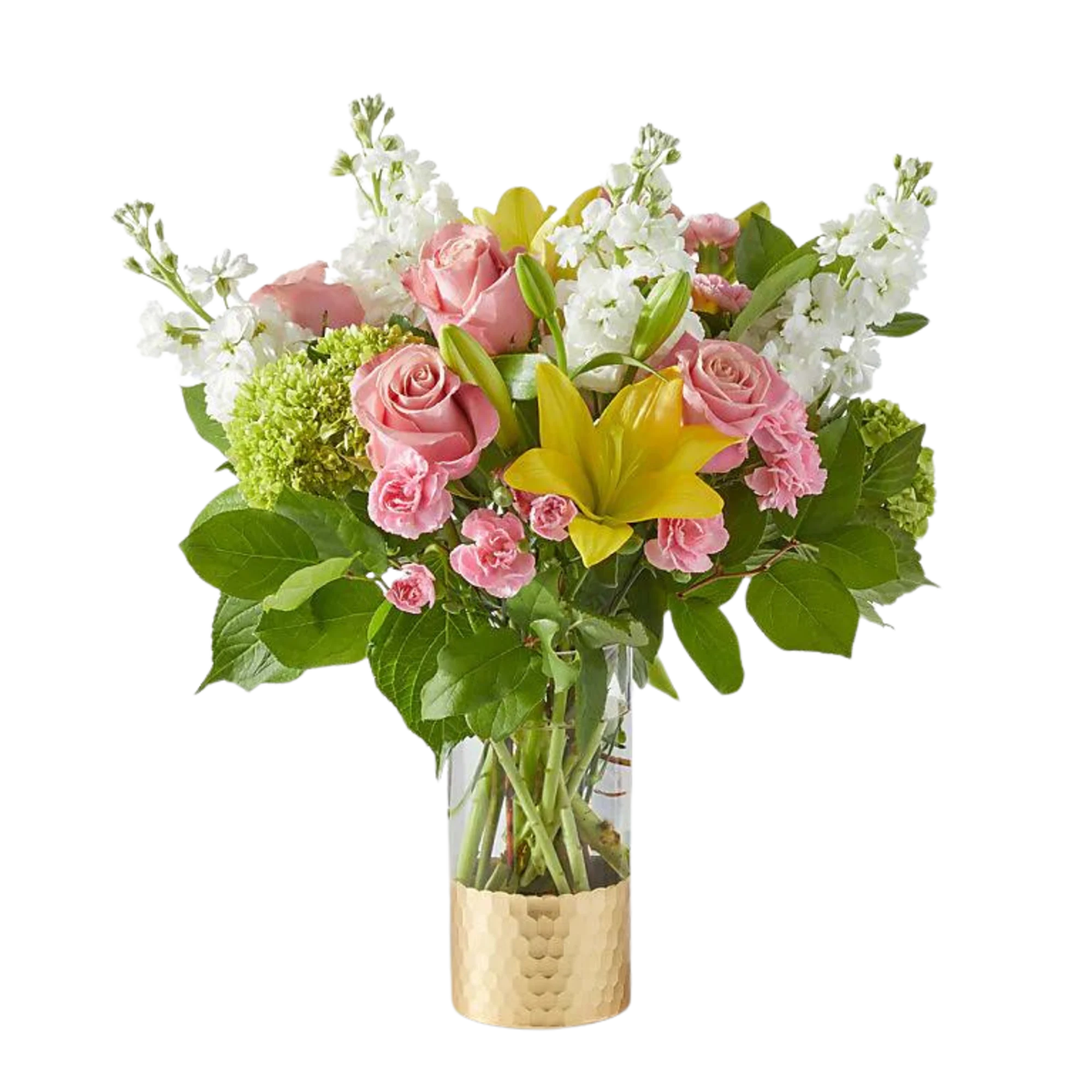 Pink roses, yellow lilies, and white blooms arranged in a clear vase with a gold base.