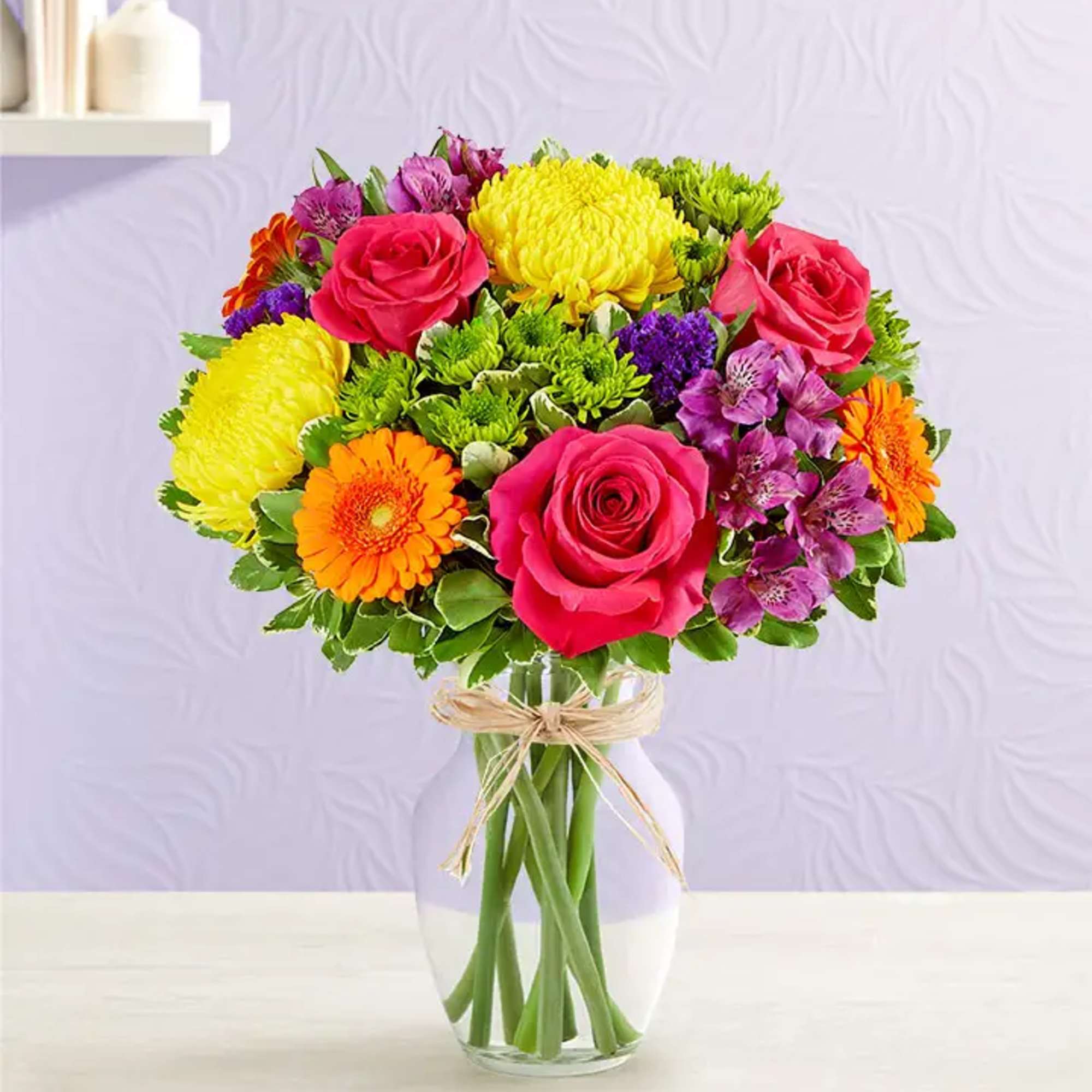 Colorful bouquet of roses, chrysanthemums, and gerbera daisies in a glass vase