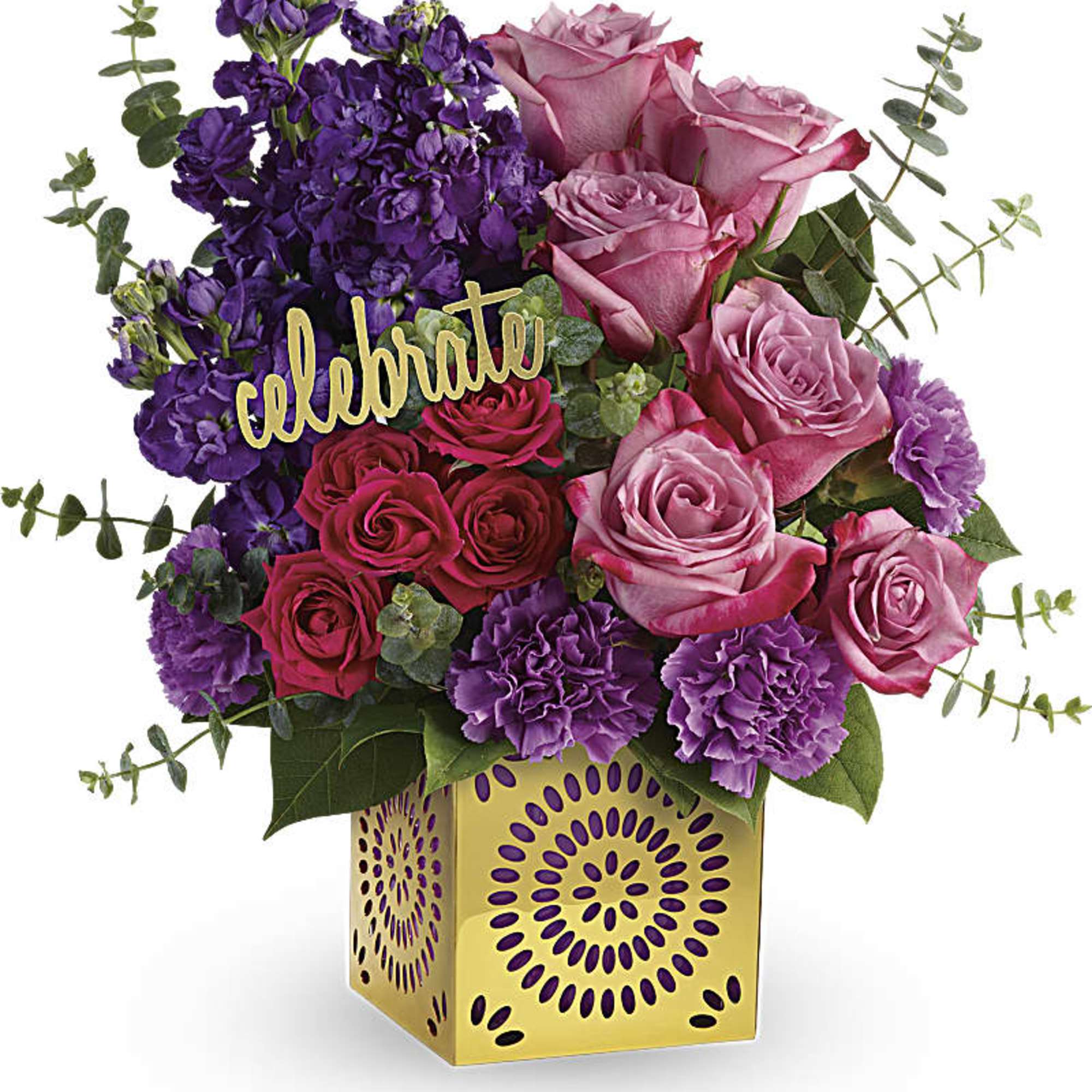 Pink and purple roses in a gold vase with a "celebrate" pick