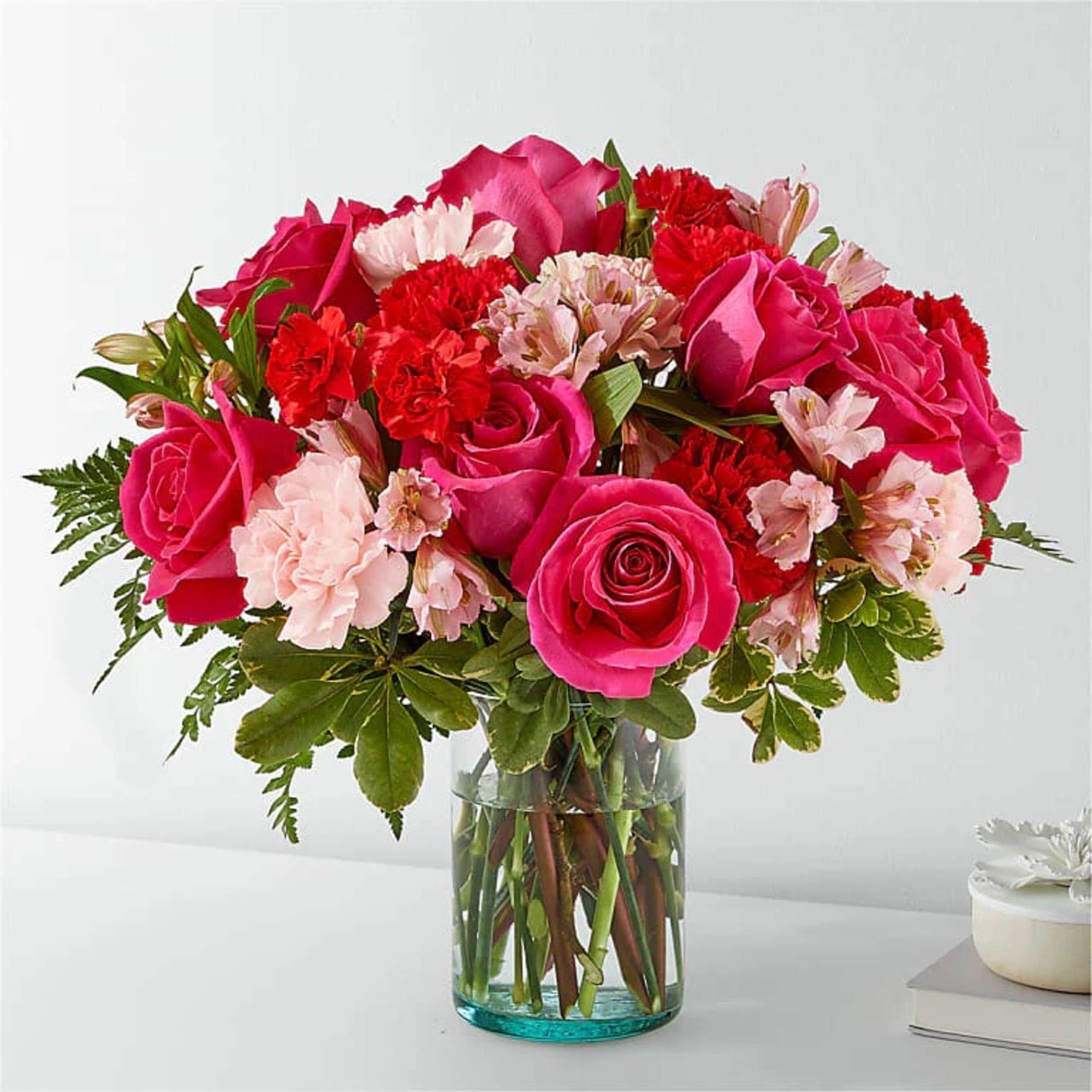 Pink roses and carnations in a clear glass vase