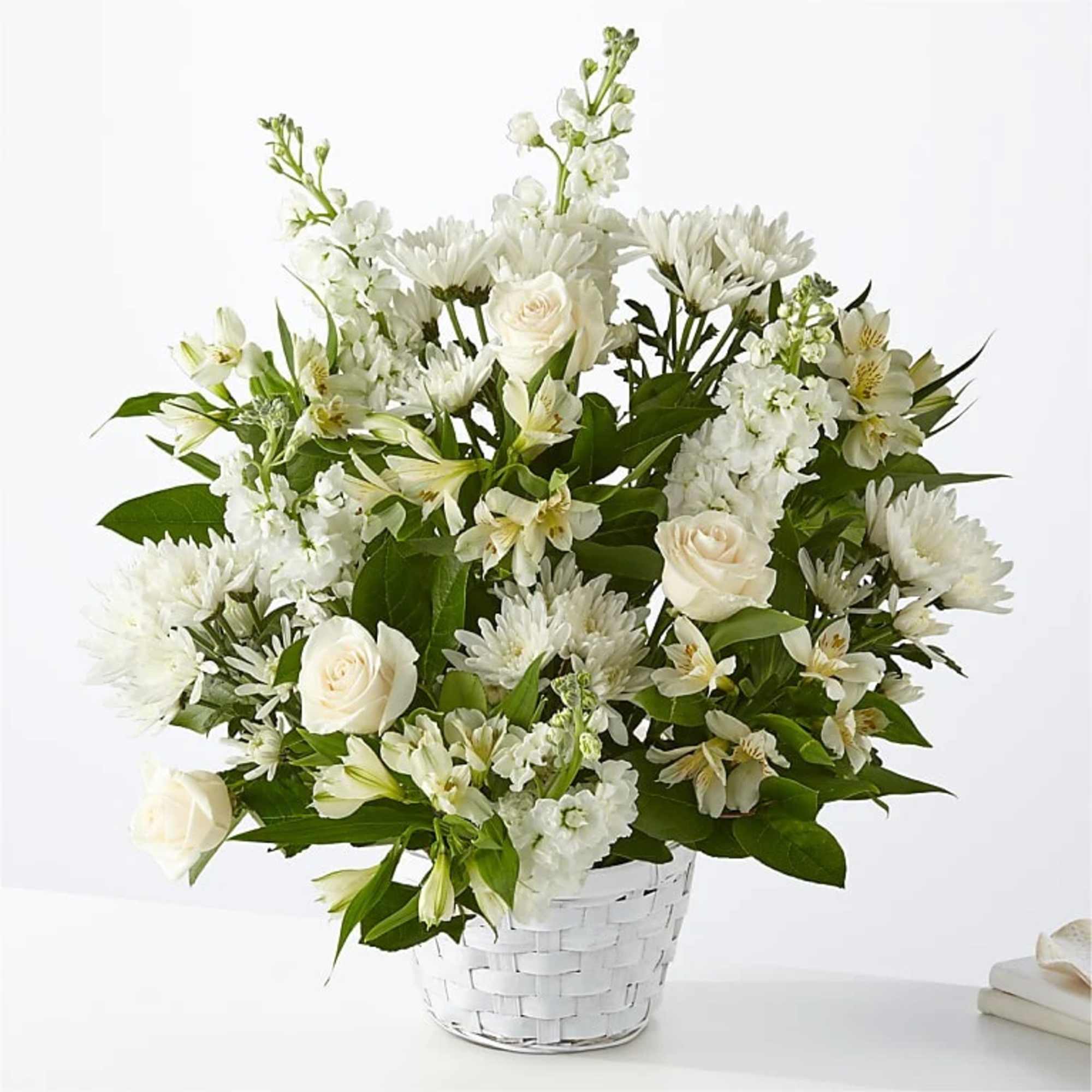 White roses and mixed white flowers in a white basket