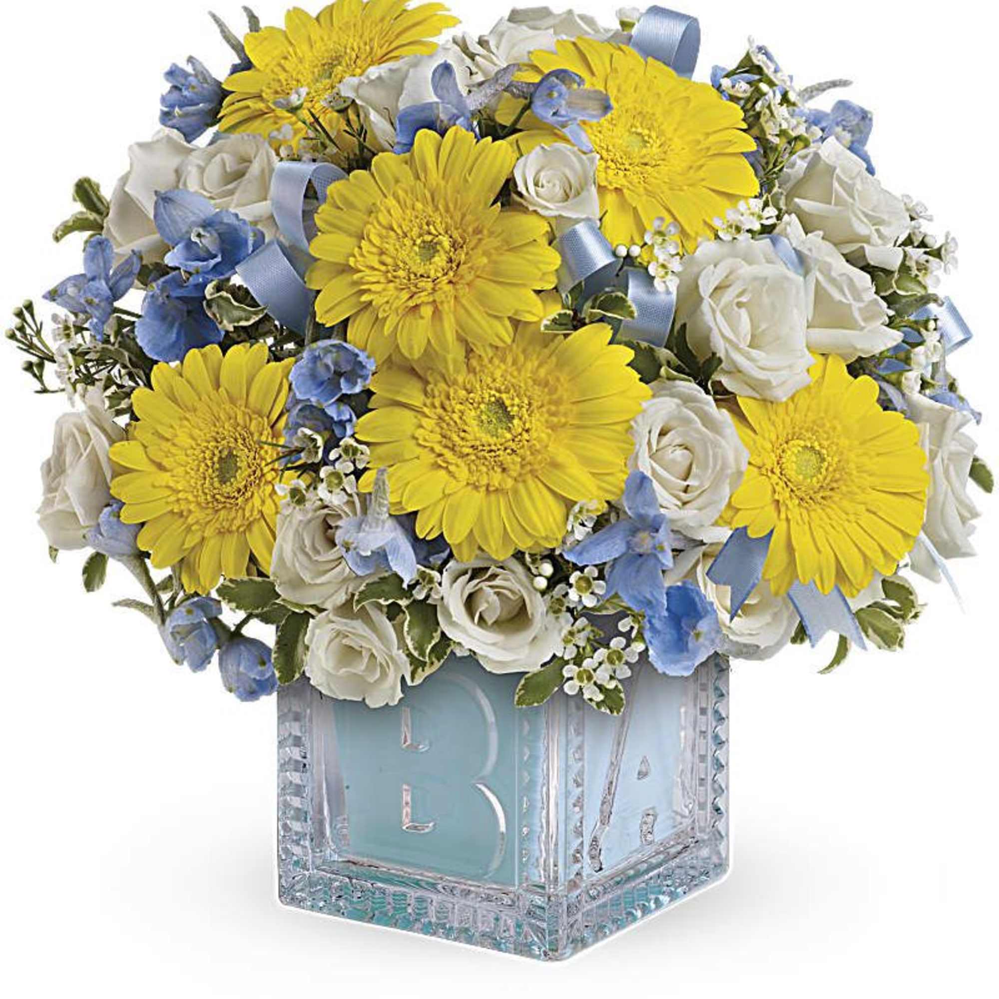 Yellow gerbera daisies and white roses in a clear glass cube vase